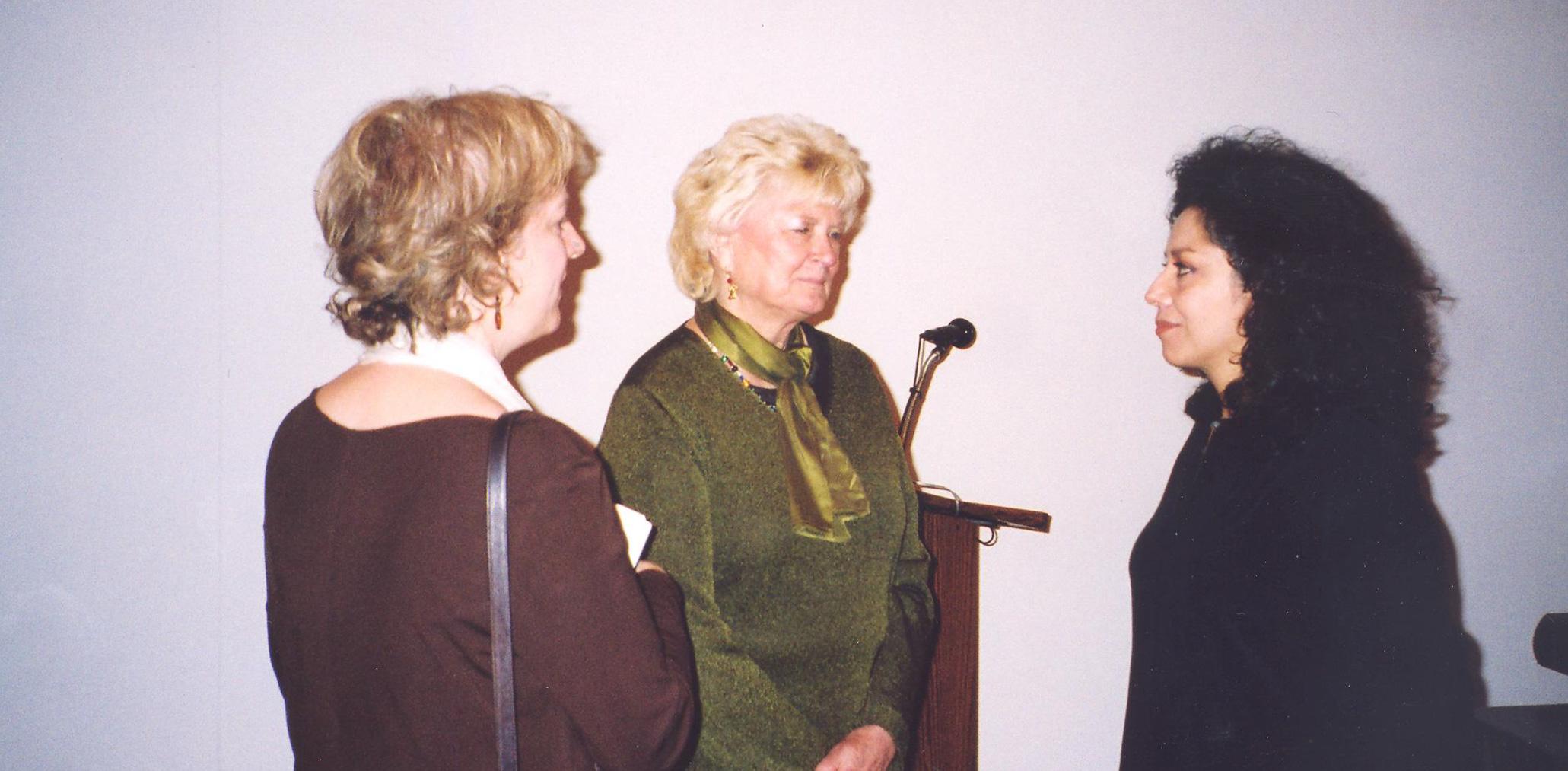 Doris Salcedo speaks with two event attendants.