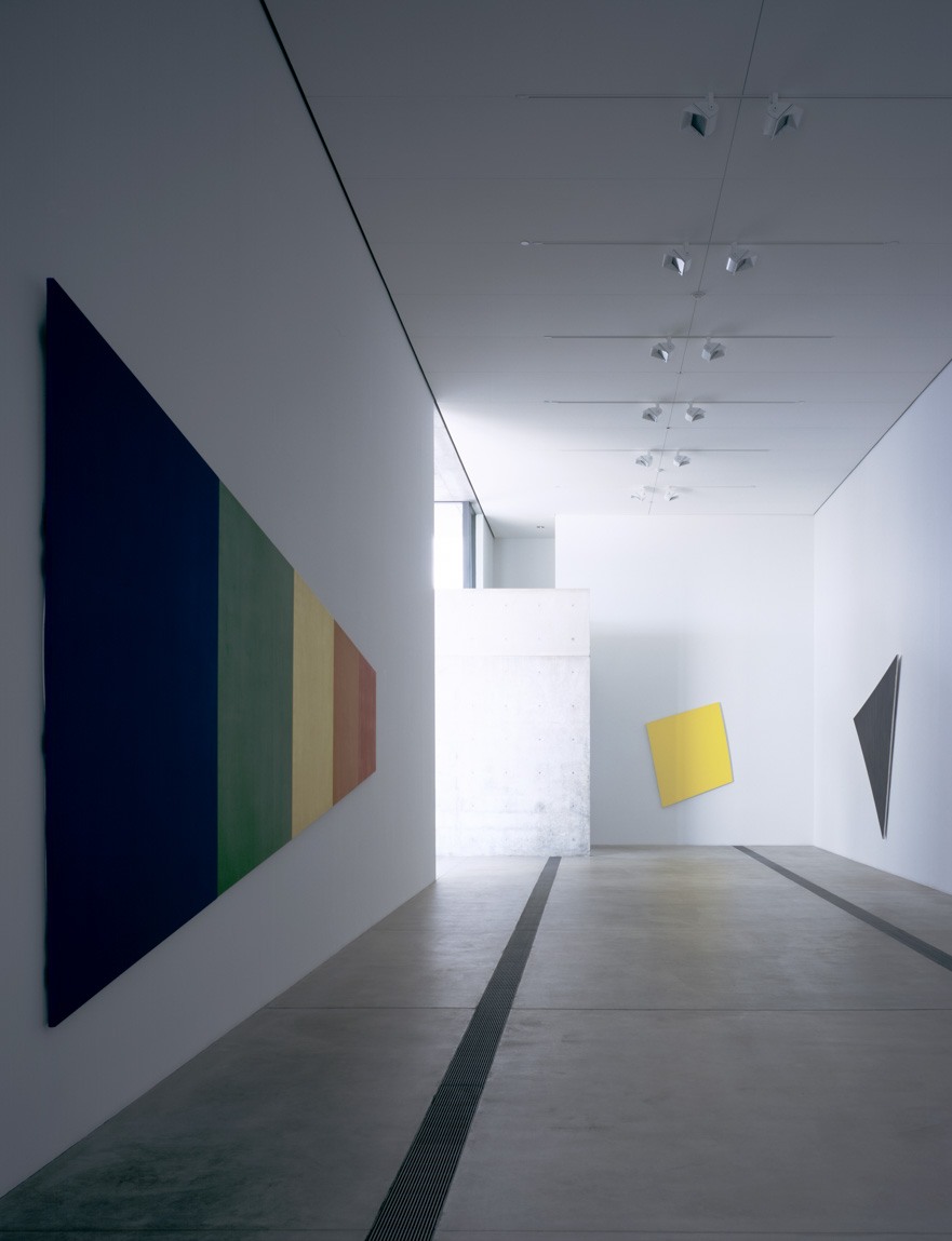 A view of Kelly's work in the Main Gallery, which includes a tilted yellow square, a spectrum piece, and a black triangle.