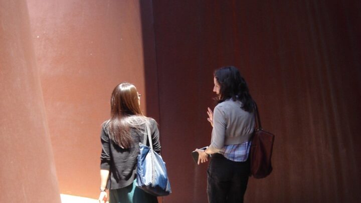 Two visitors chat and walk through Serra's 