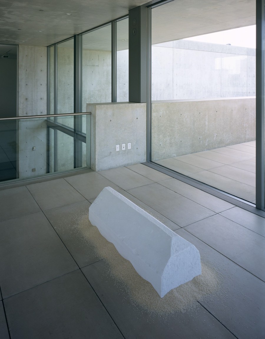 A view of Wolfgang Laib's "Rice House," a marble triangular rectangle sitting on a bed of rice in the Mezzanine.