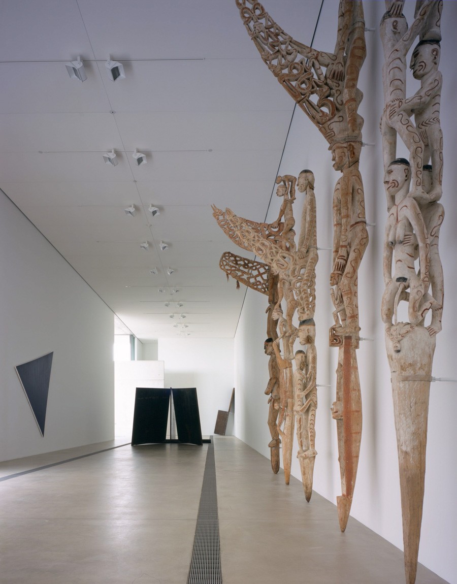A view of five intricately carved Asmat ancestor poles and Richard Serra's "Joplin" in the Main Gallery.