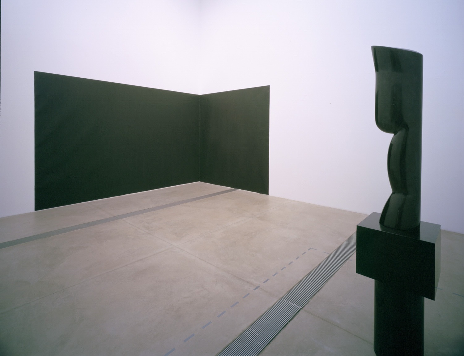 Two pieces stand opposite each other in the Cube Gallery: Serra's "Pacific Judson Murphy," a large black rectangular piece which runs across one wall to another in a corner, and Brâncuși's "Agnes E. Meyer," a tall black marble figure.