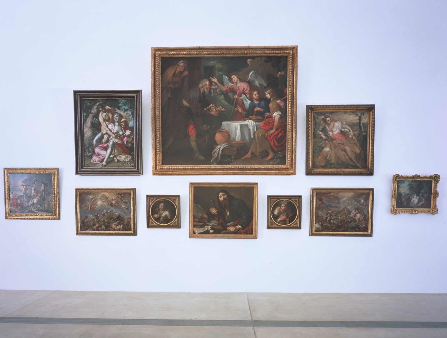 A group of paintings hung salon-style in the Main Gallery.