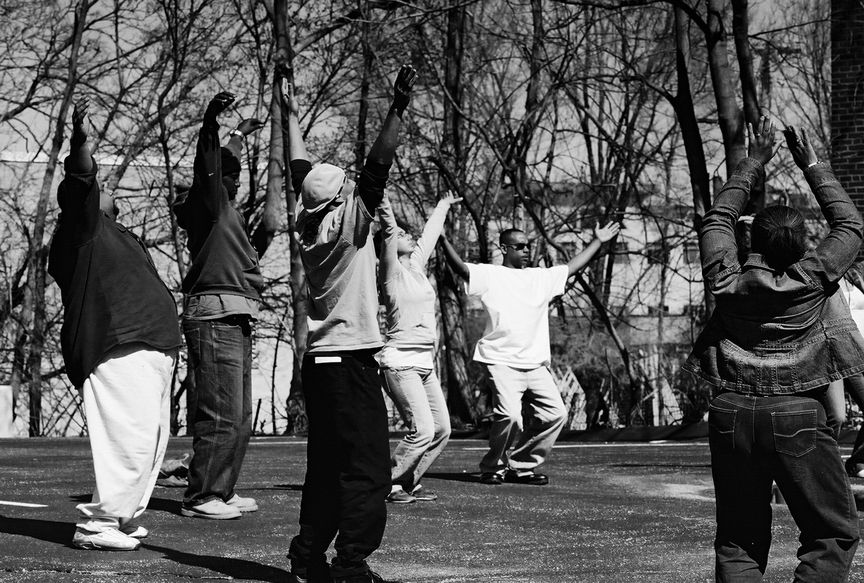 A black and white photograph of a group of participants rehearses outside.