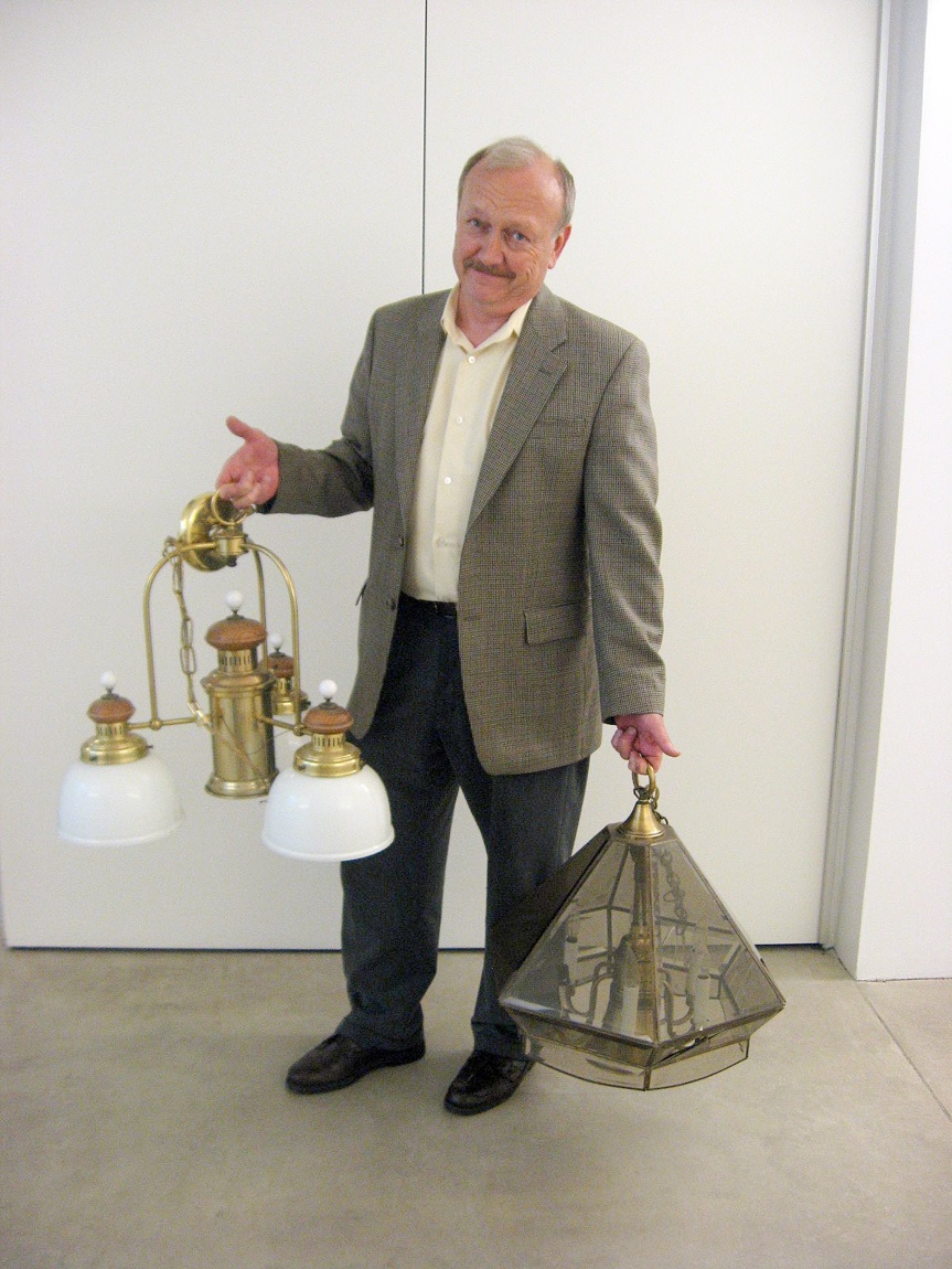 A Lamp Project donor holds two chandeliers.