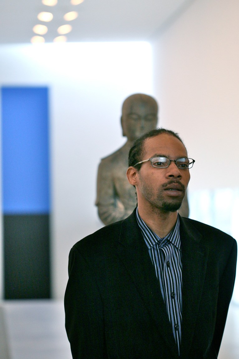 Participant speaks to guests in front of a sculpture in the Main Gallery.