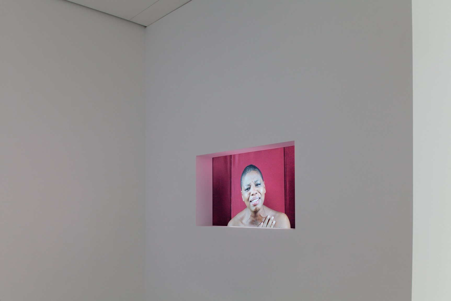 An exhibition view of Nina Saro-Wiwa's film "Sarogua Mourning," indented into a gallery wall.