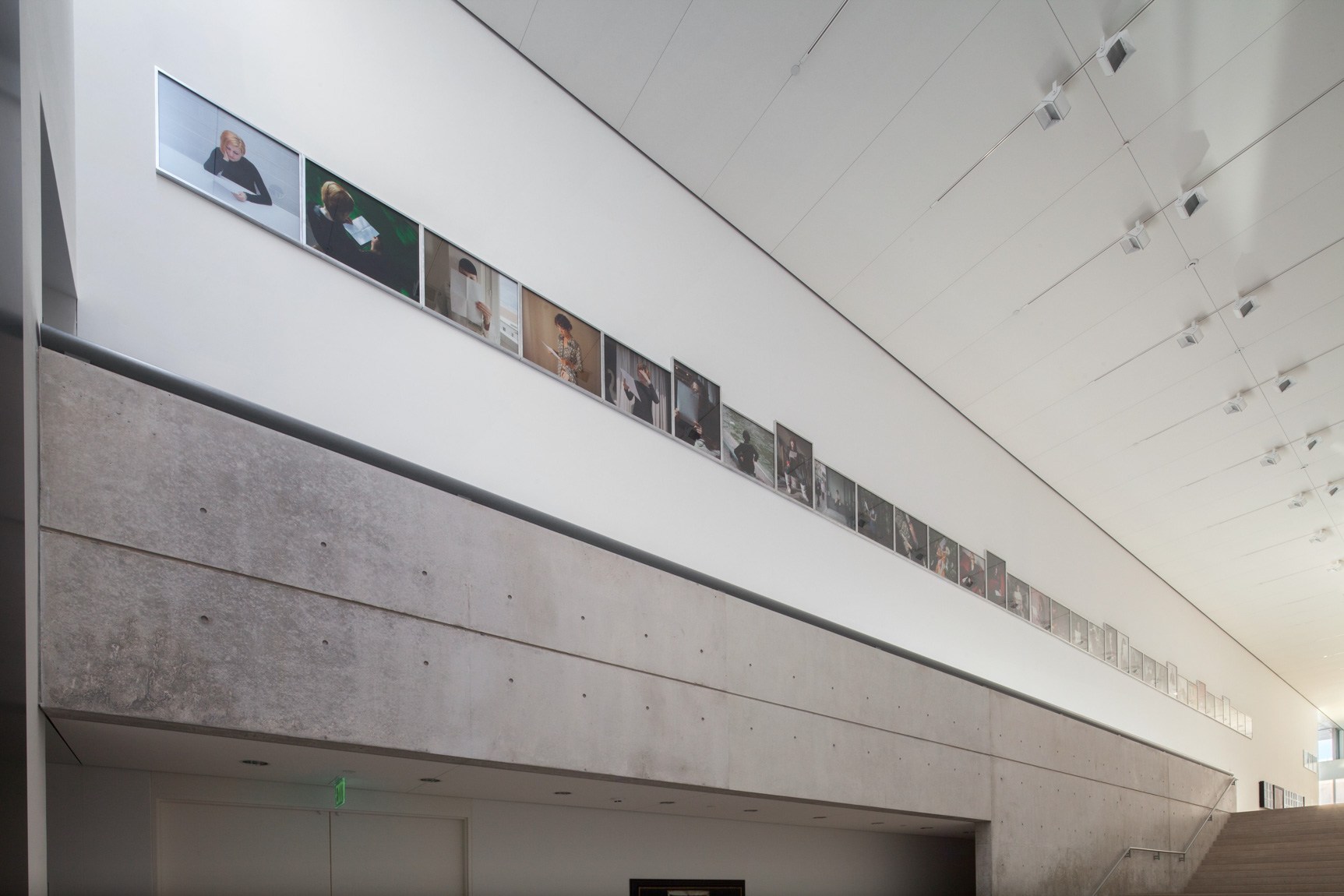 A section of Sophie Calle's "Take Care of Yourself," photos displayed in a line along the Main Staircase.