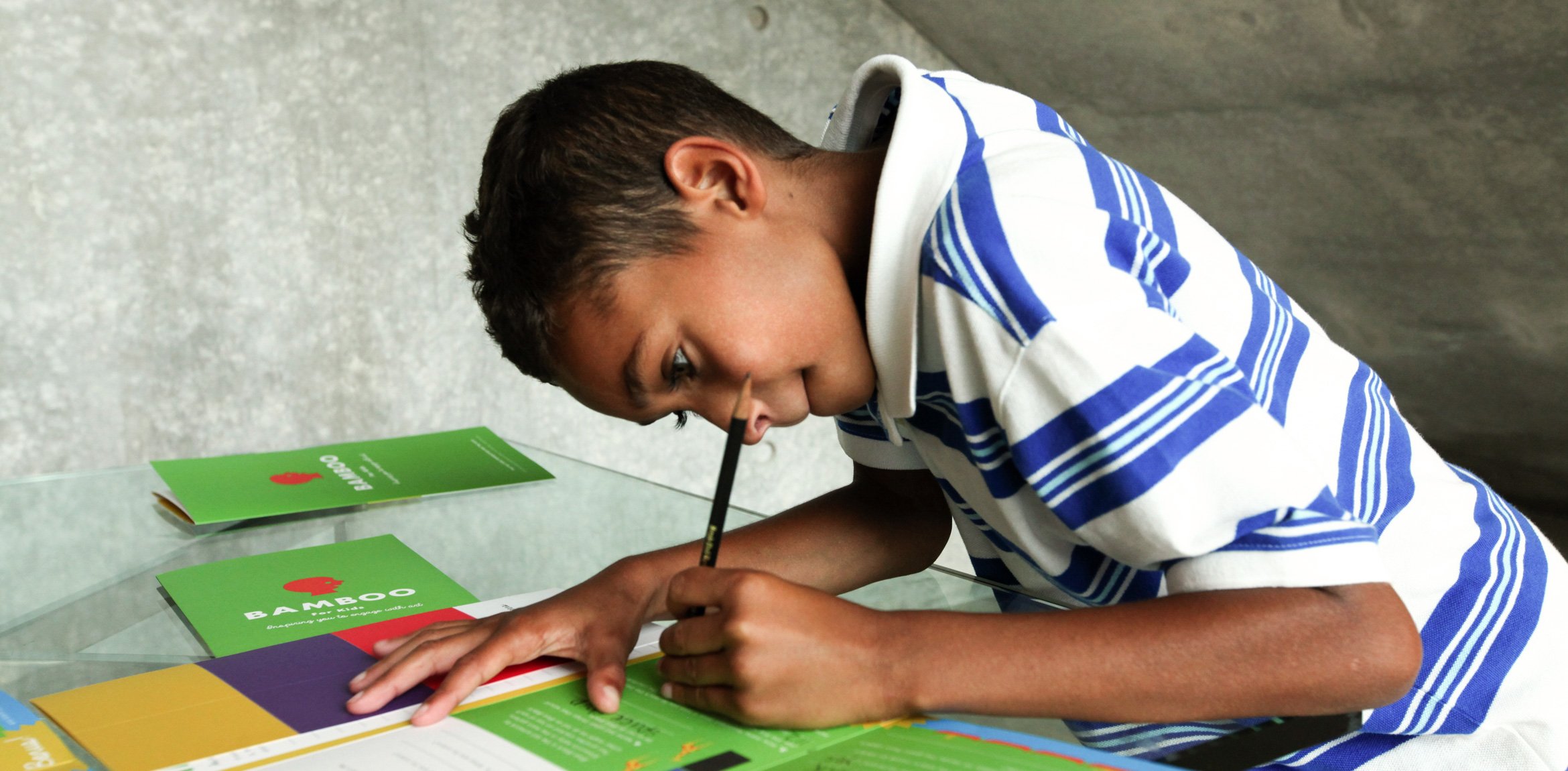 A child leaning over a activity guide while working on it.