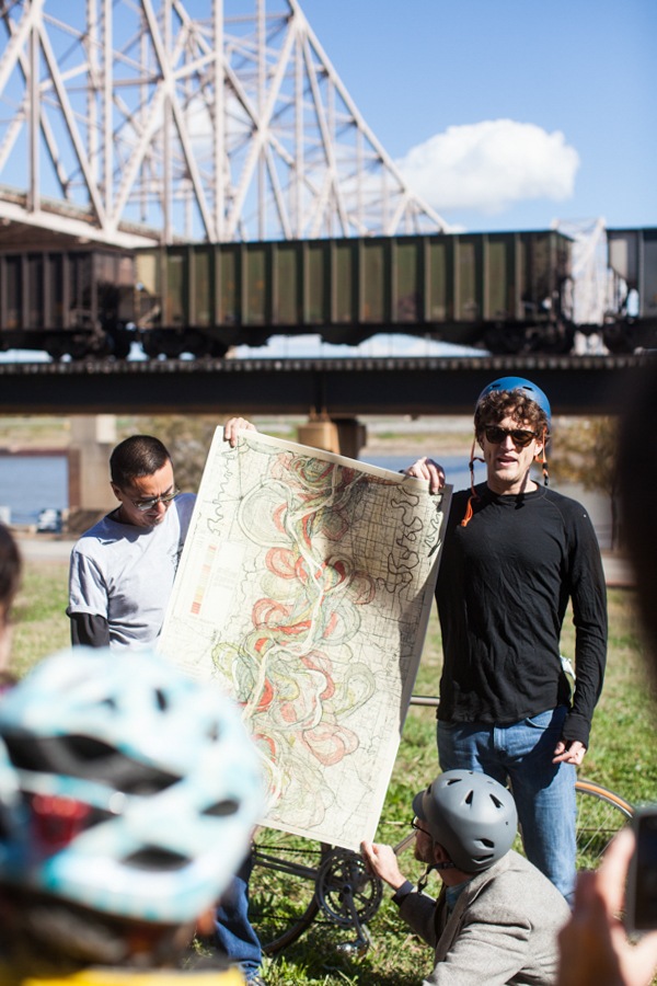 Two participants hold up a map of the Mississippi River for the tour to see.