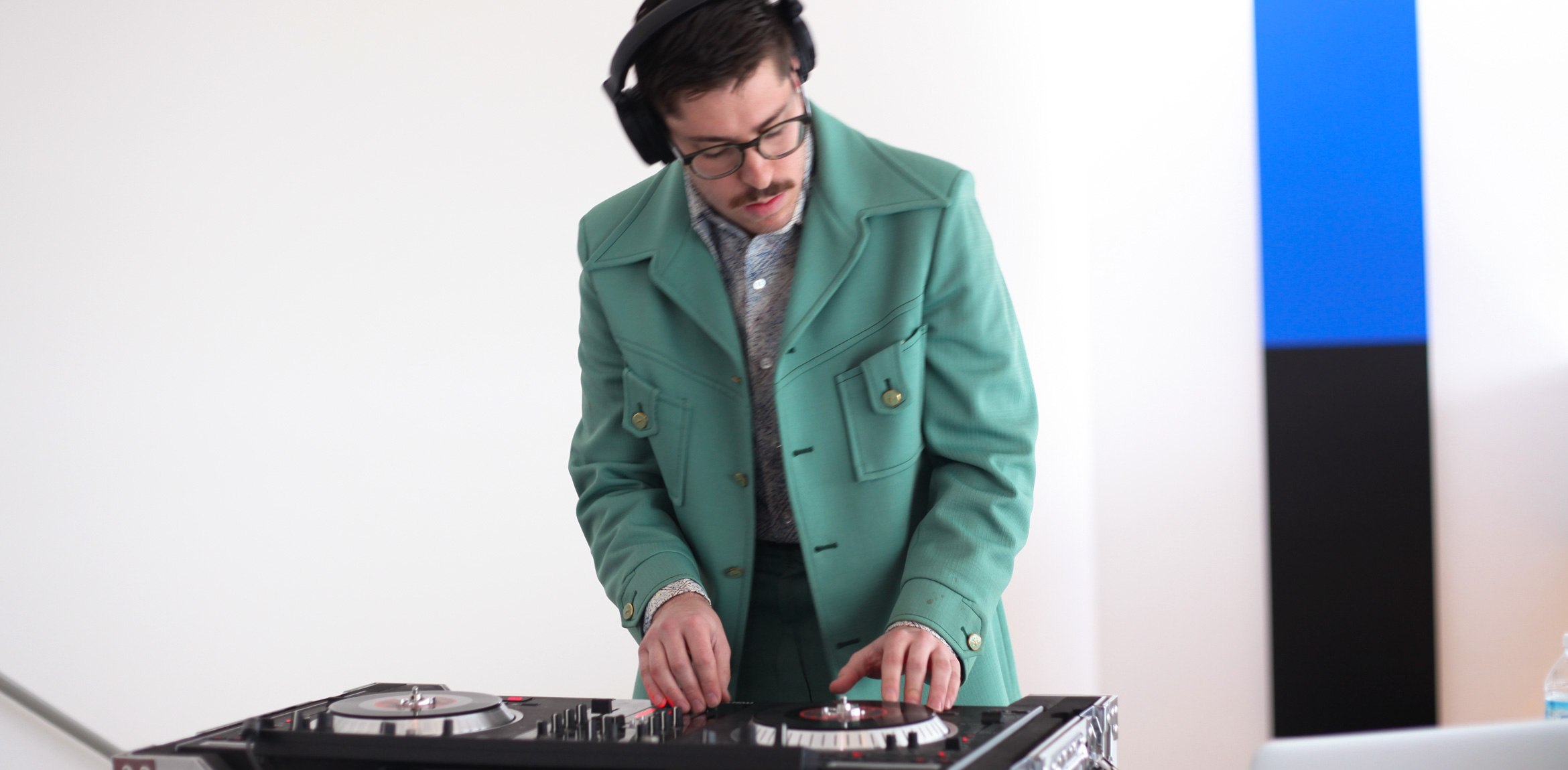 A DJ mixing at a turntable in the main gallery, with "Blue Black" by Ellsworth Kelly in the background.