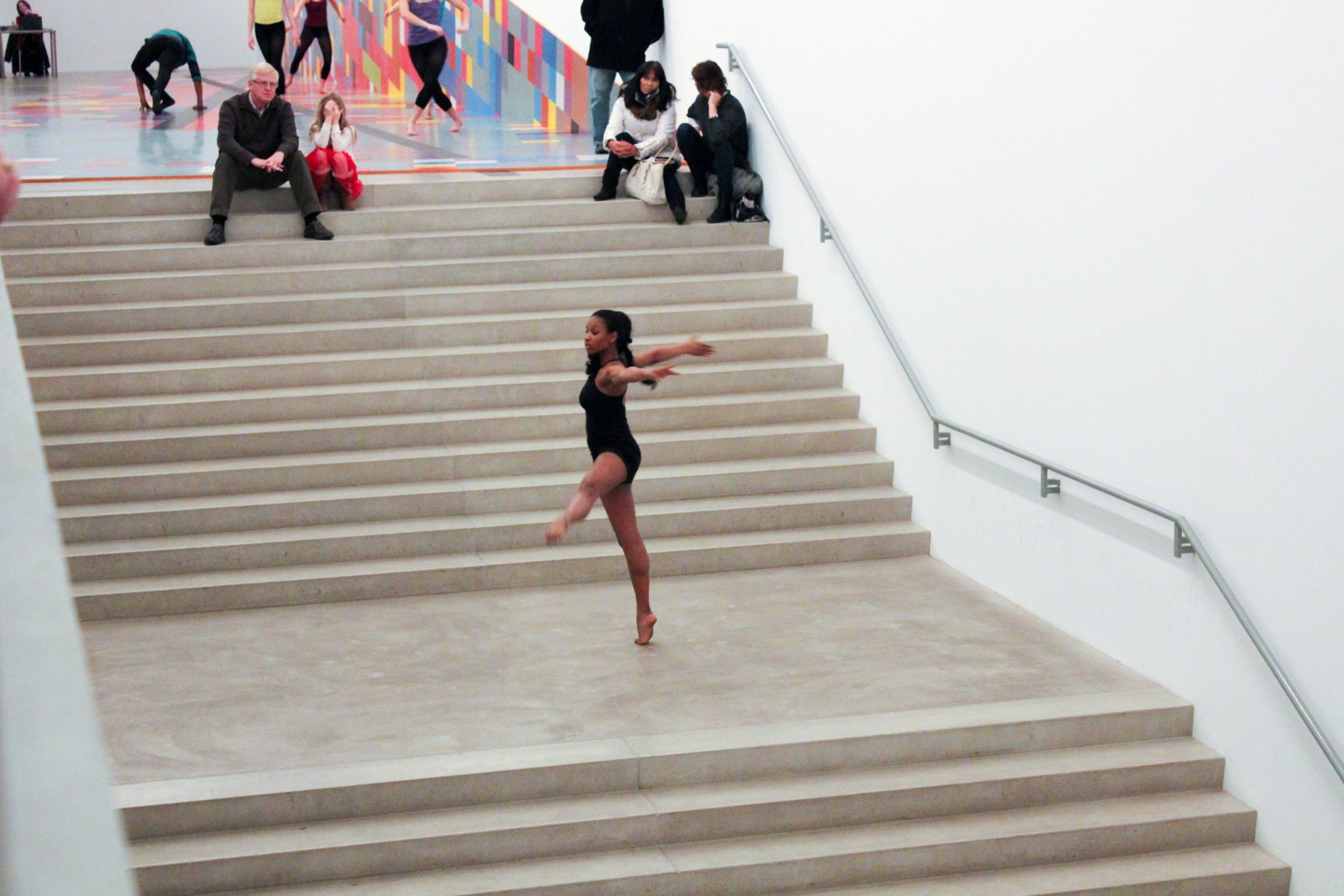 A COCA dancer performs in a black leotard on the Main Staircase for guests.
