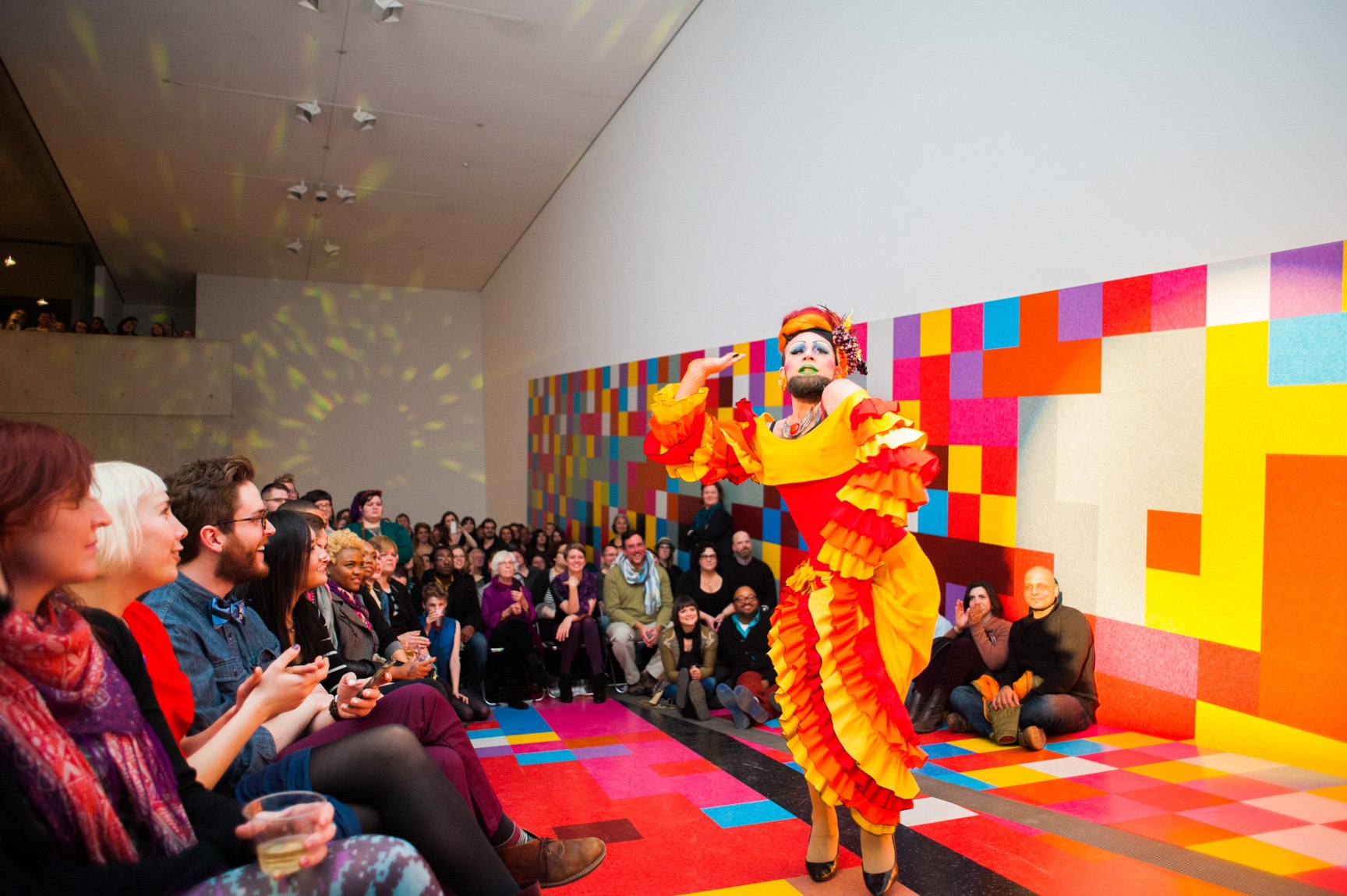 Pinko performs wearing a bright orange and yellow dress in front of David Scanavino's installation "Candy Crush" for a large audience in the Main Gallery.