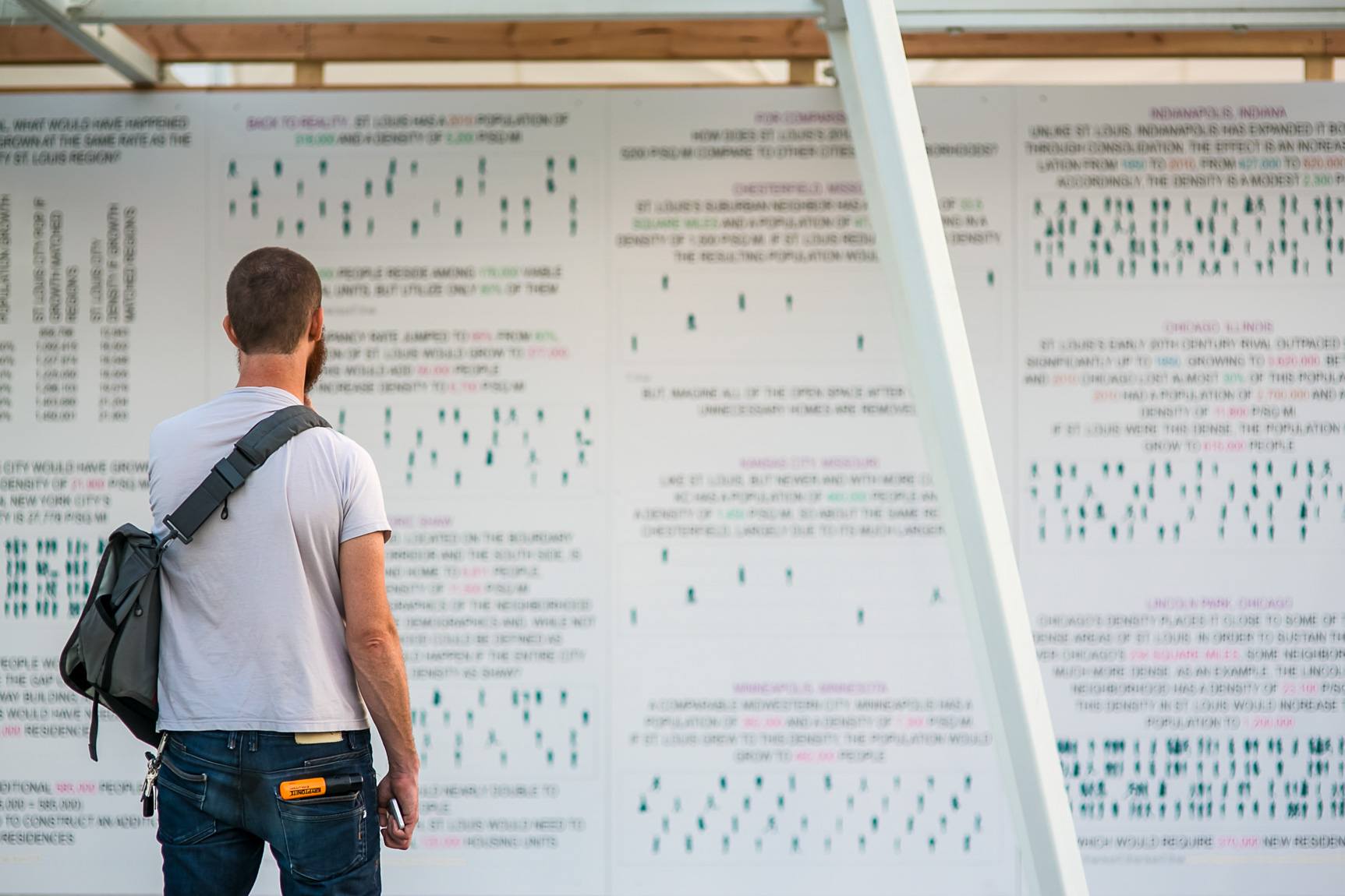 A visitor stands before a wall of diagrams.