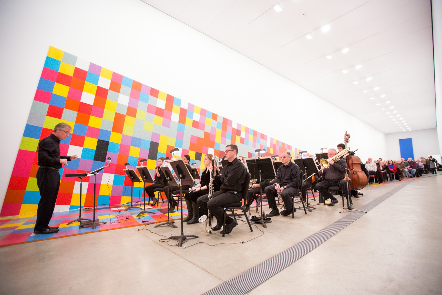 David Robertson conducts symphony members in the Main Gallery, framed by David Scanavino's installation "Candy Crush."