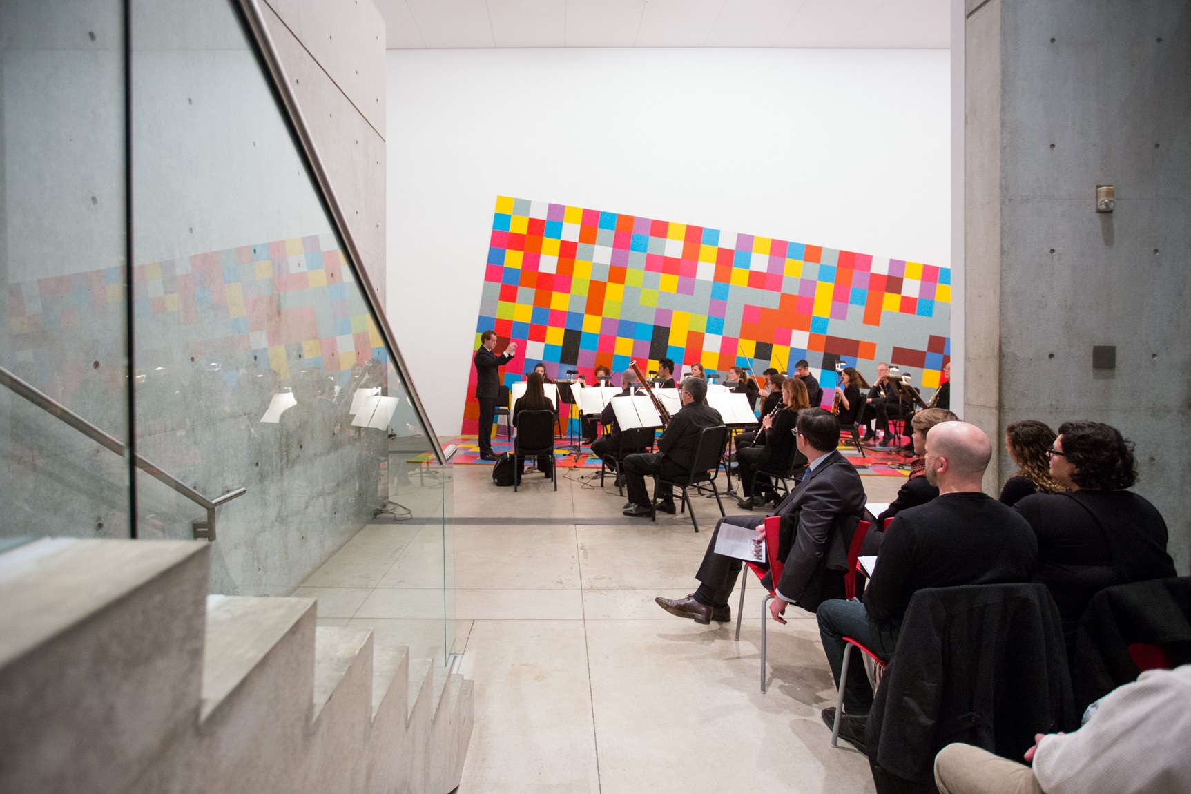 Audience members sit in front of the Water Court doors to watch the performance in the Main Gallery.