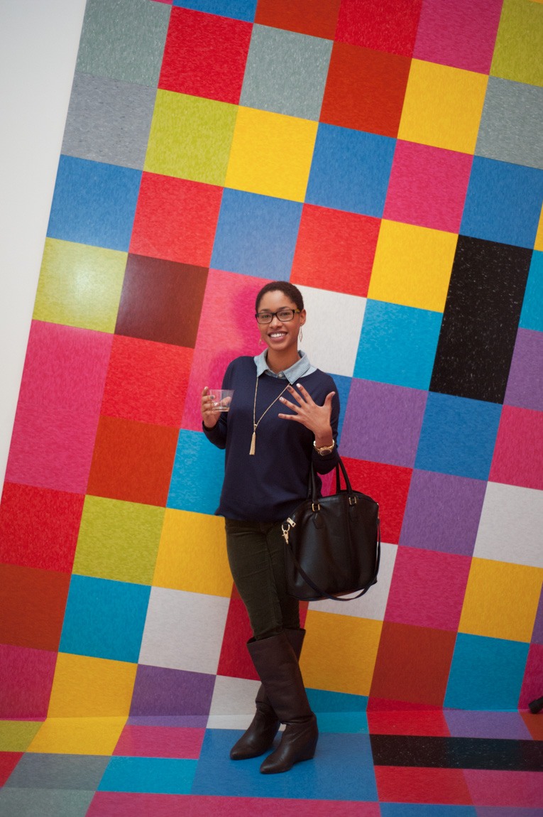 A visitor smiles in front of David Scanavino's installation "Candy Crush."