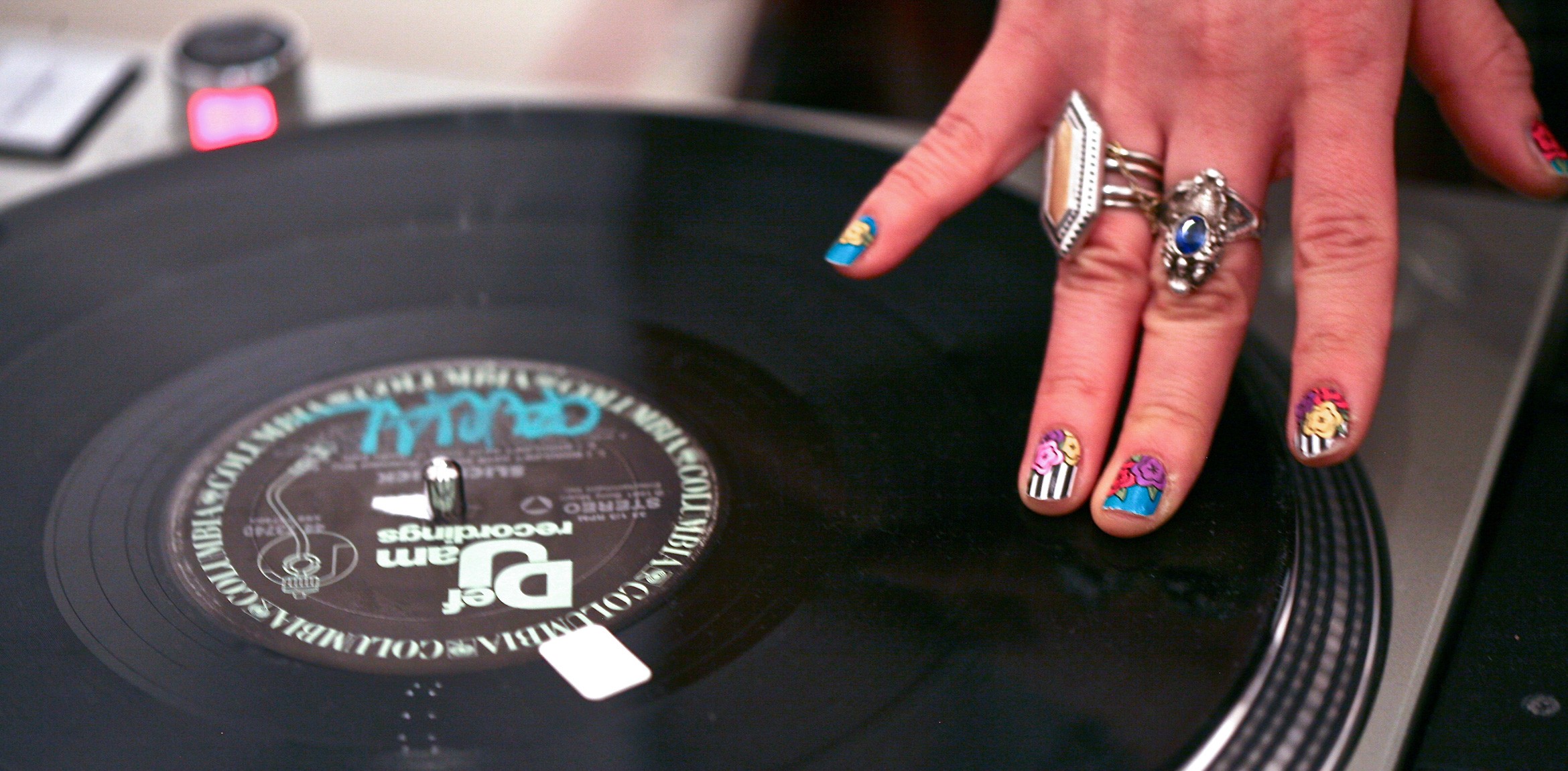 A closeup of Jenn DeRose's hand spinning a record.