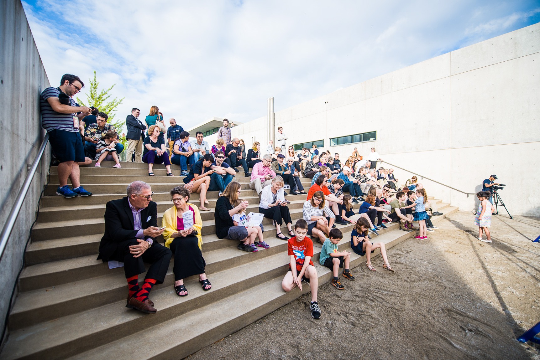 A large audience gathers on the Courtyard stairs to watch performers.