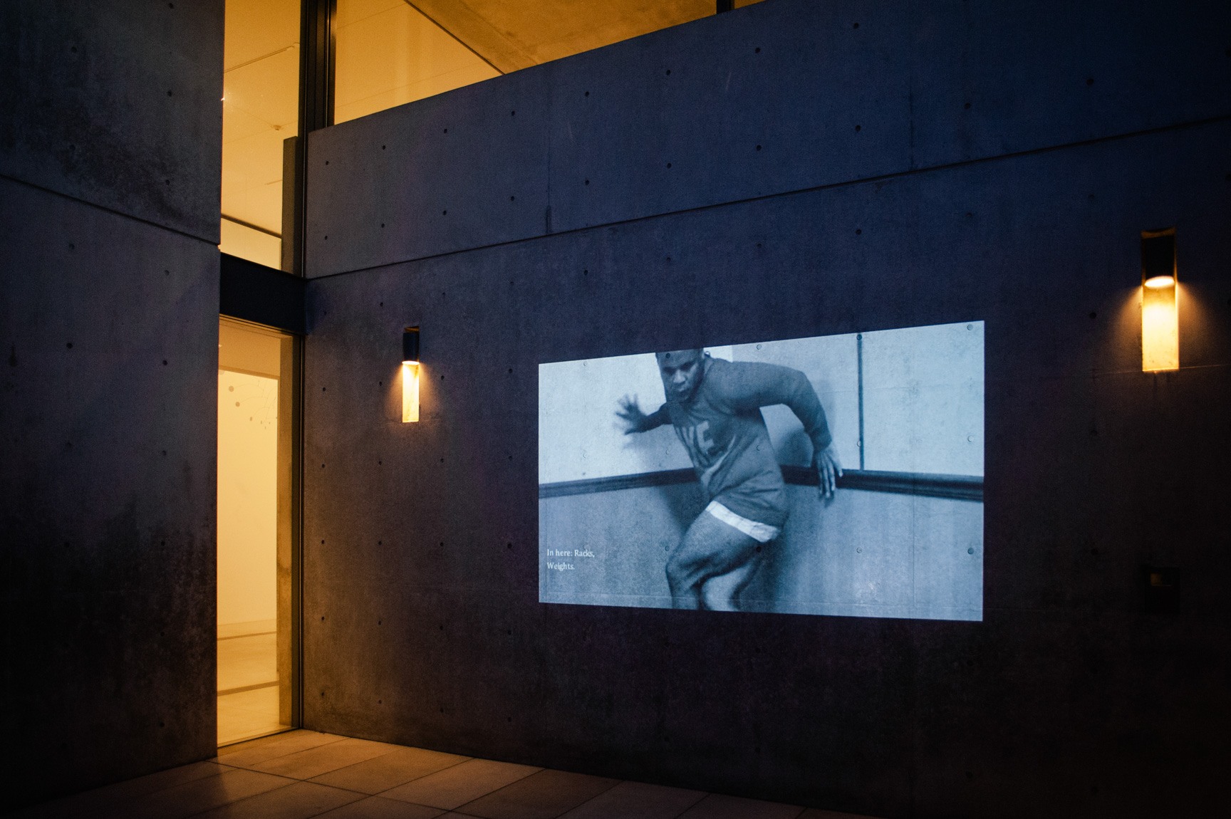 A black and white film projected on the concrete wall outside in the entryway.