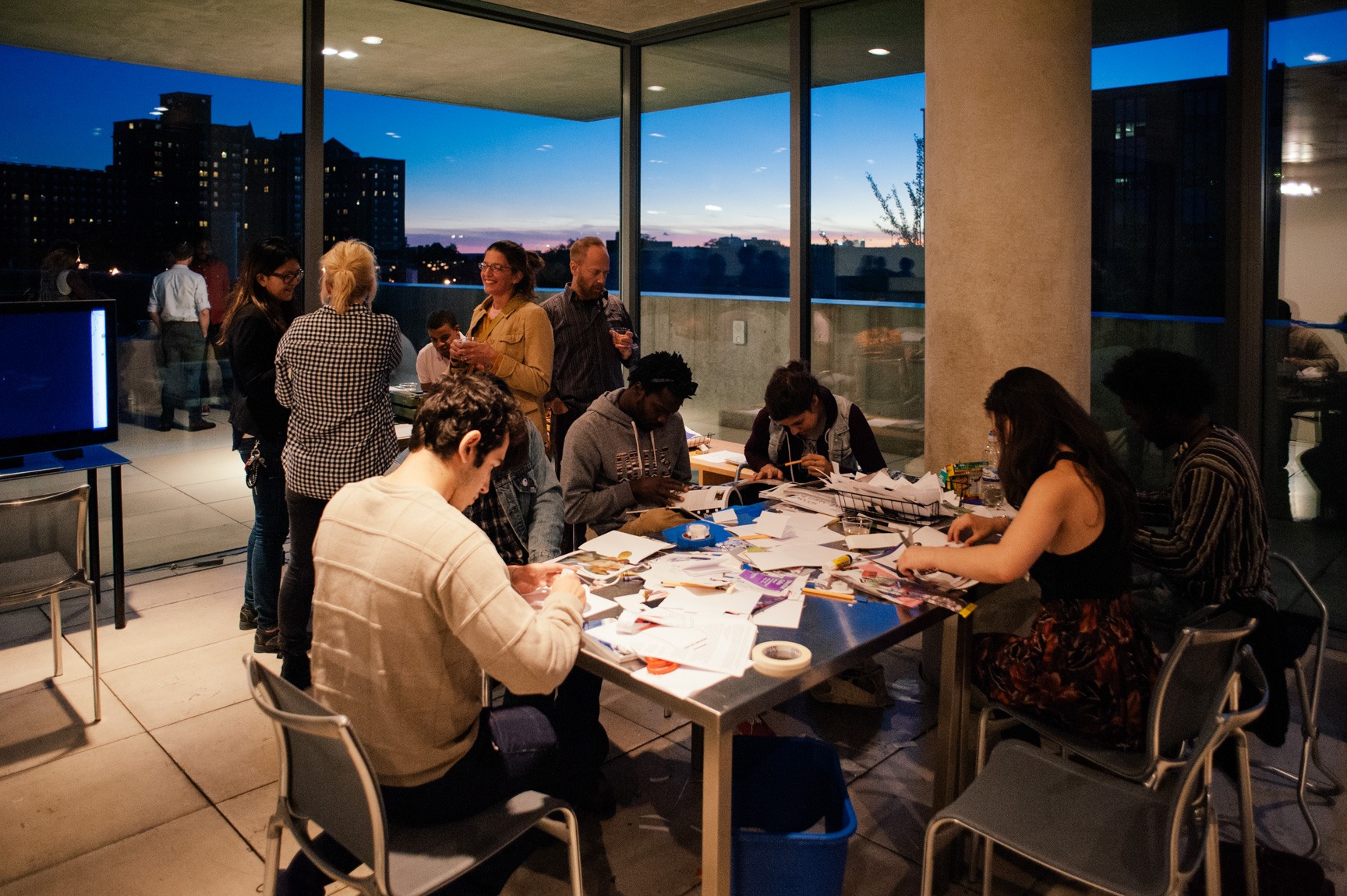 Visitors engage in a workshop activity at tables in the Mezzanine.