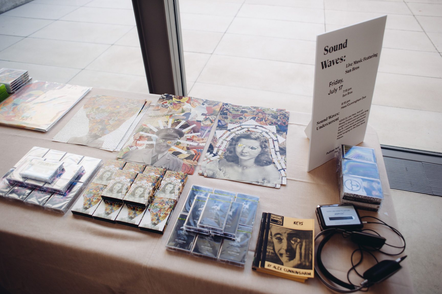A table next to the Water Court windows covered with posters and cassettes from the musical acts.