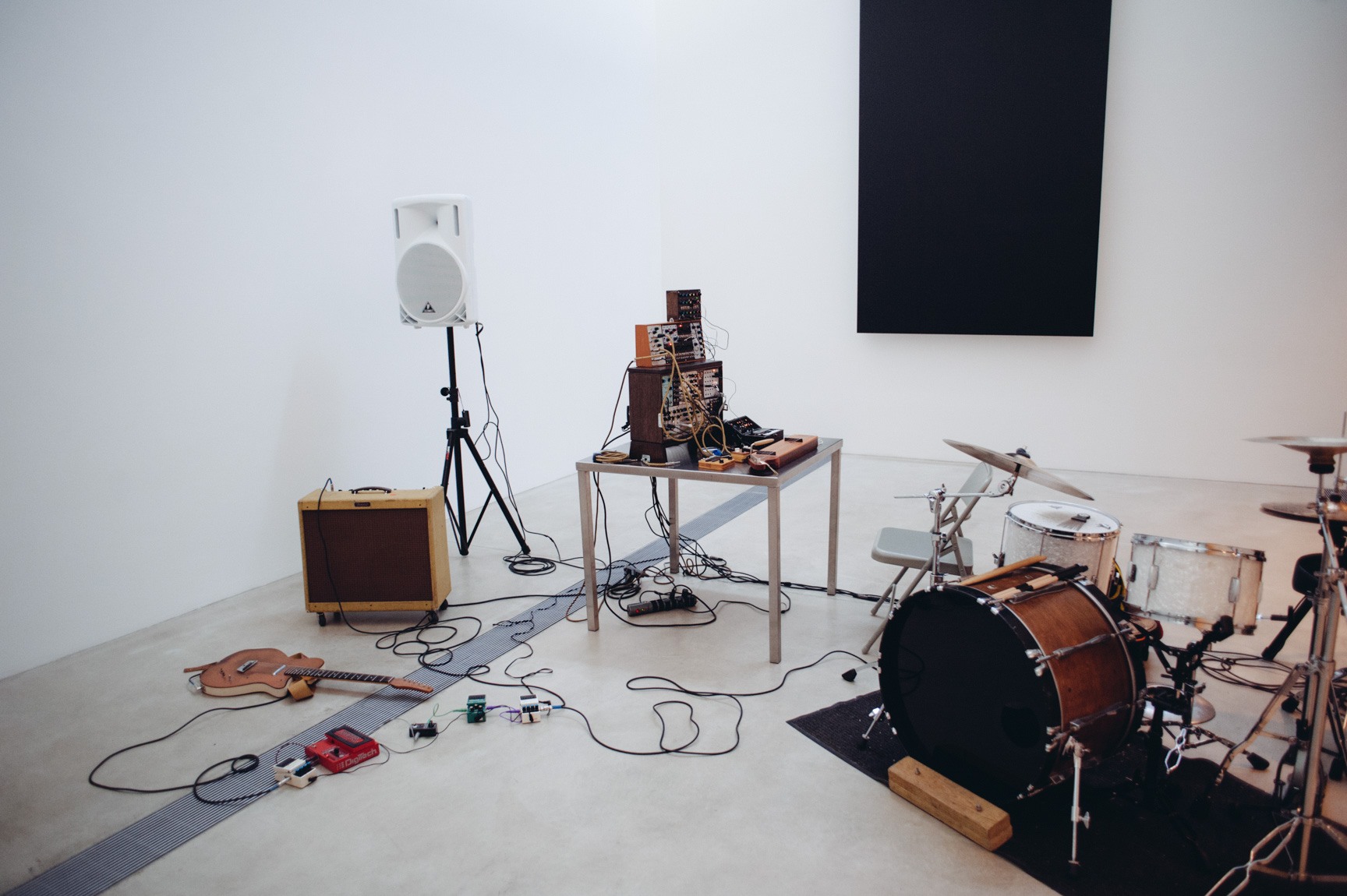 A view of the musician's instruments in front of Kelly's "Blue Black," including a drum set, a guitar, and a homemade synthesizer.