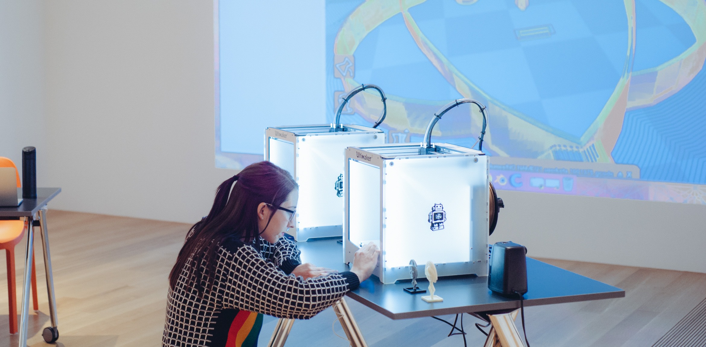 A participant interacts with one of the 3-D printers.