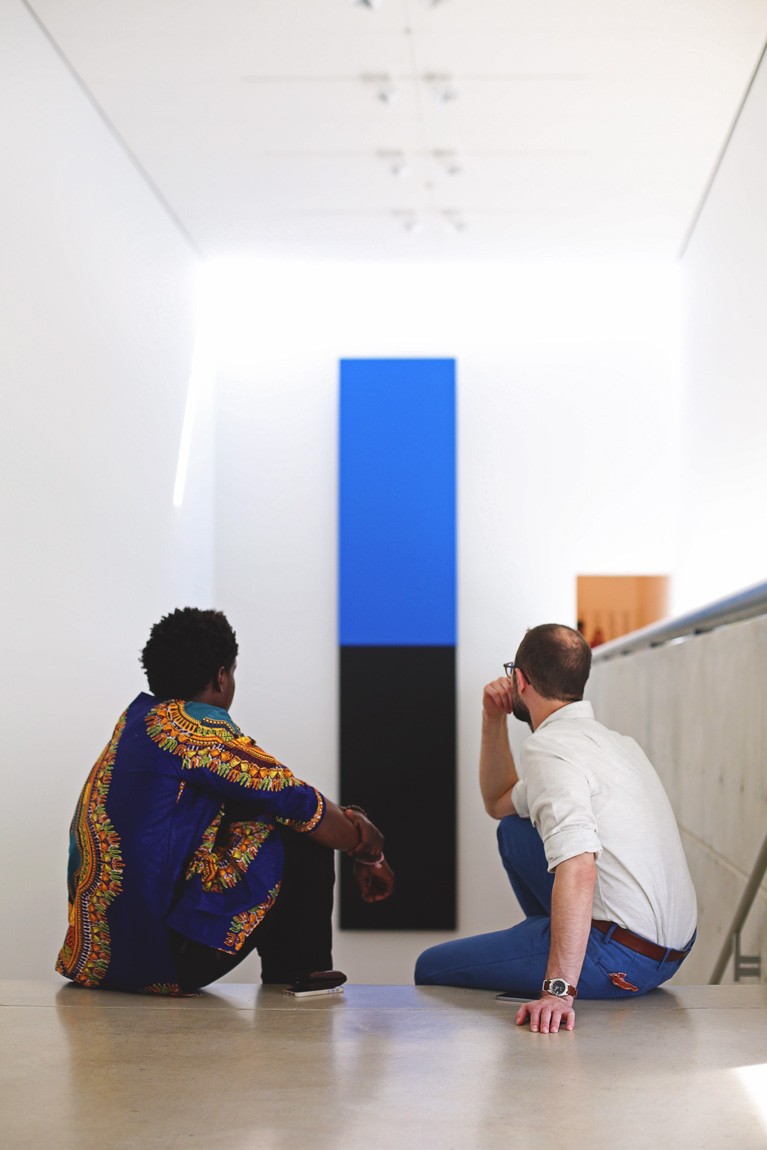 Two visitors sit at the top of the Main Staircase and look at Ellsworth Kelly's "Blue Black."