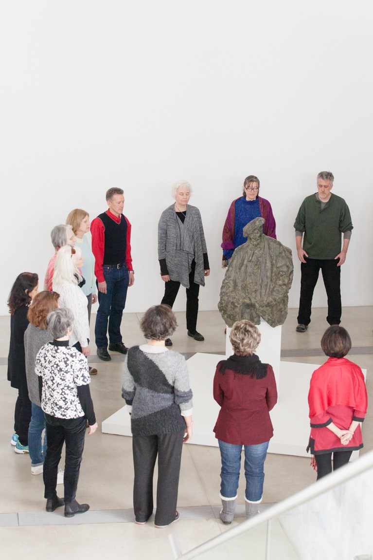 Workshop attendants stand in a circle in the Main Gallery around Rosso's sculpture of Henri Rouart.
