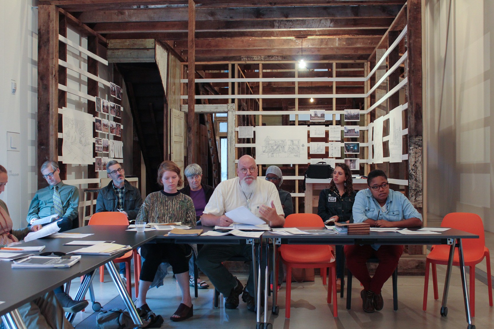 Workshop attendants sit at desks in the Main Gallery, with the installation "4562 Enright Avenue" behind them.
