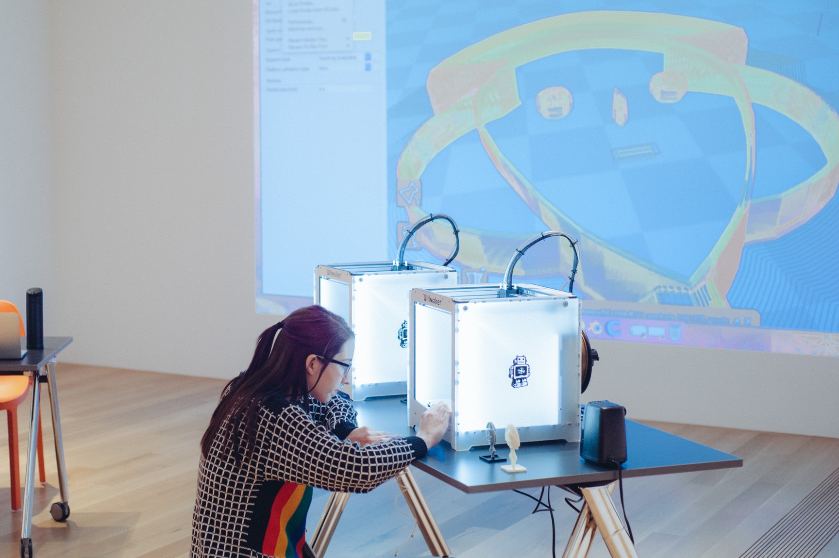 A participant interacts with one of the 3-D printers at the workshop.