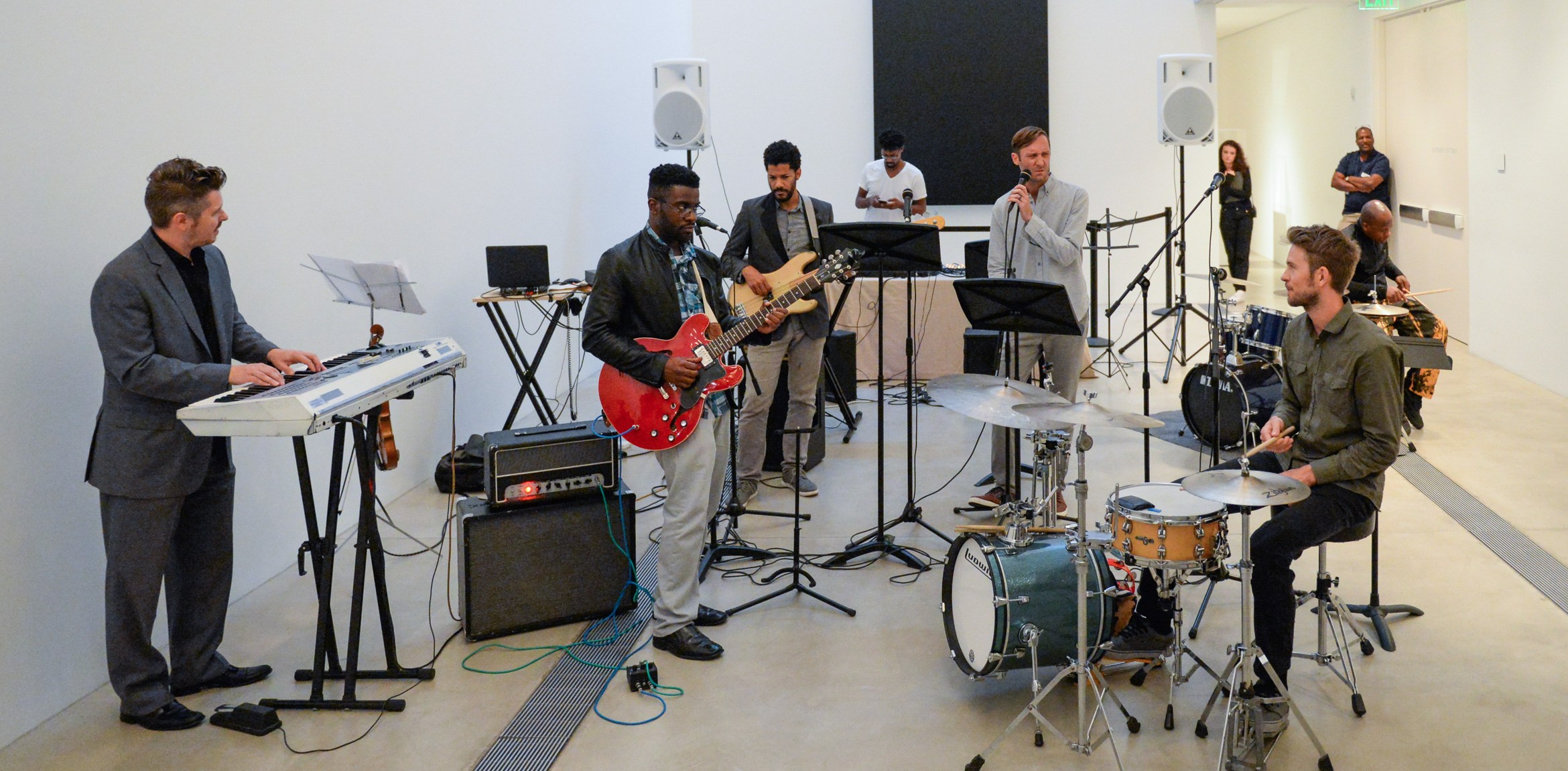 A large band performing in front of Ellsworth Kelly's "Blue Black".