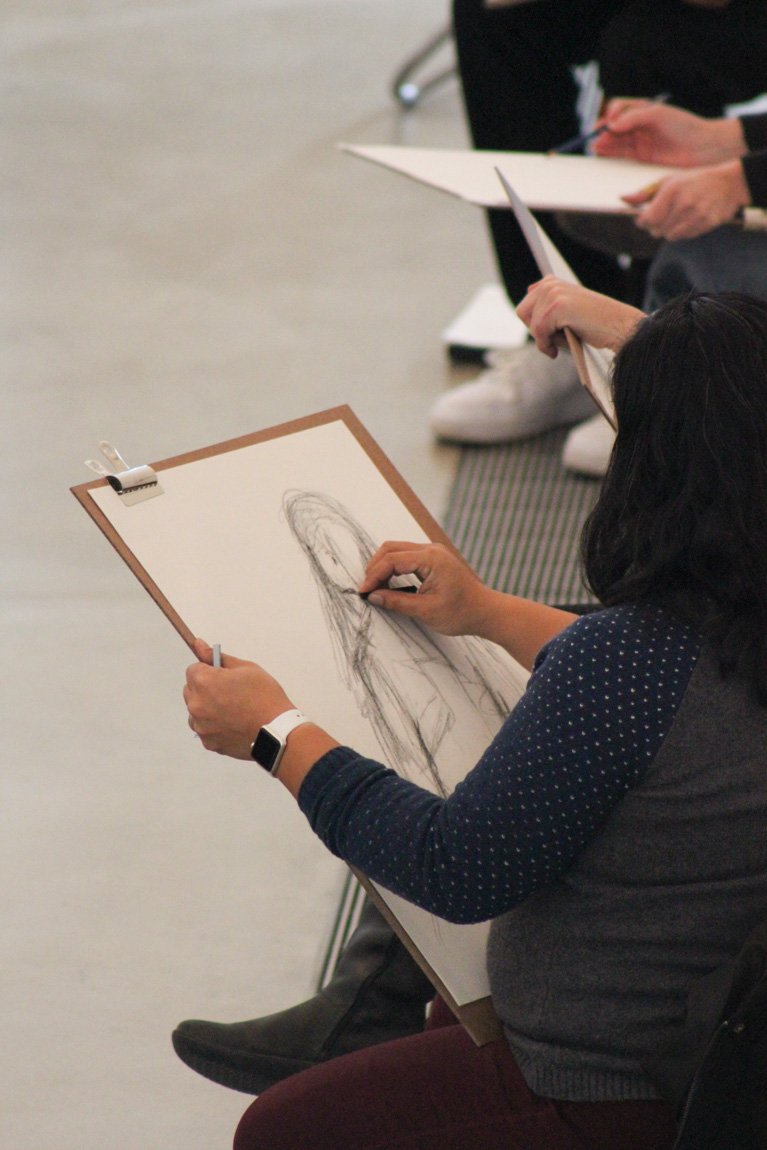 Closeup of an artist sketching for a figure drawing workshop.