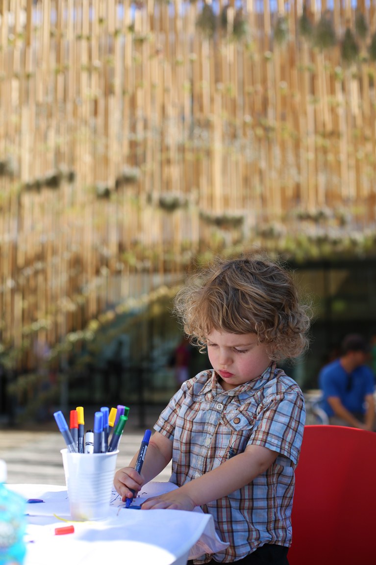 A child draws at a coloring station outside.