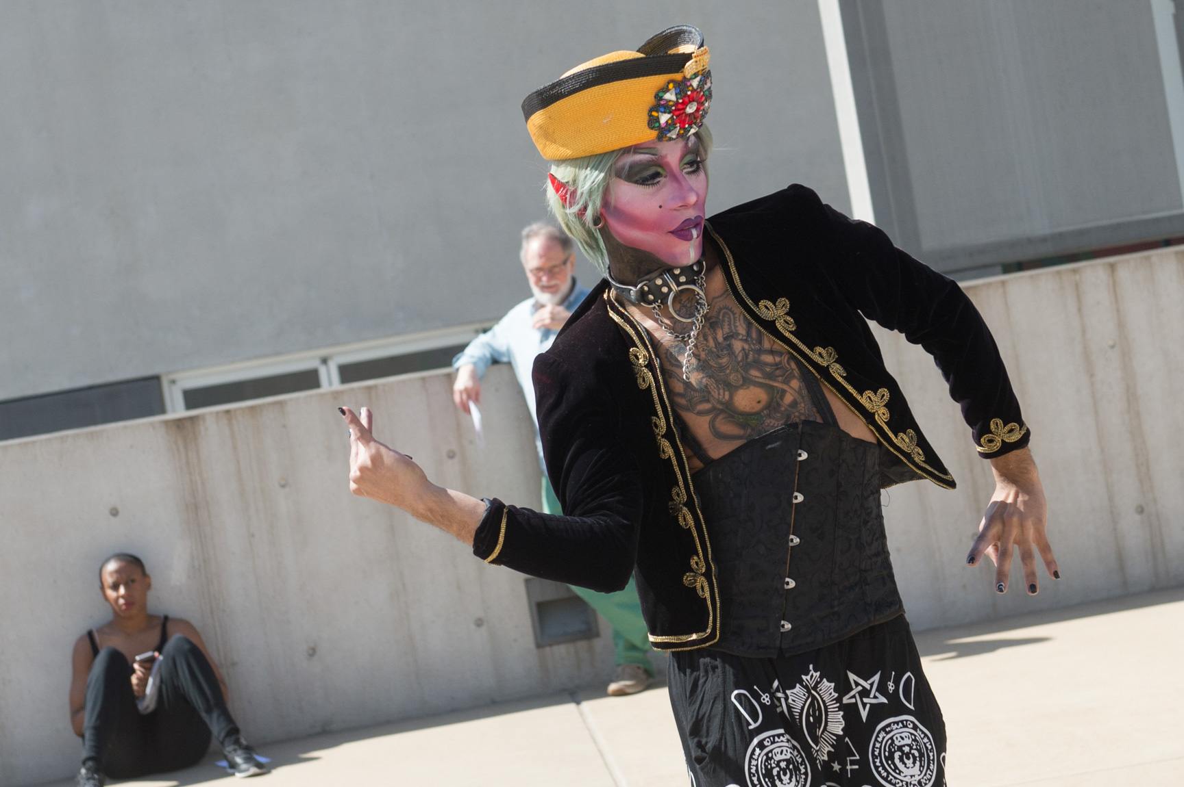 An AUNTS performer dressed in drag dances in the Courtyard for an audience.