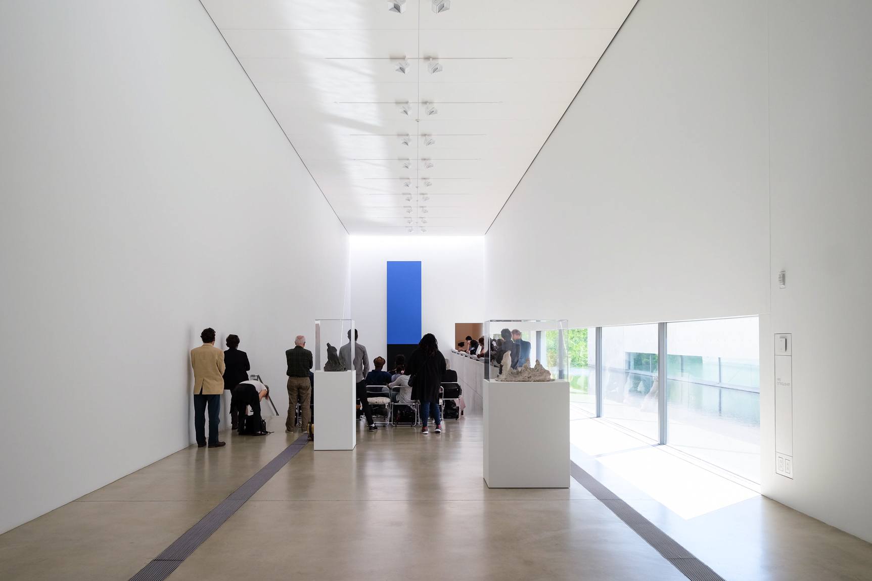 View of event-goers in the Main Gallery from behind, who are facing "Blue Black" by Ellsworth Kelly.
