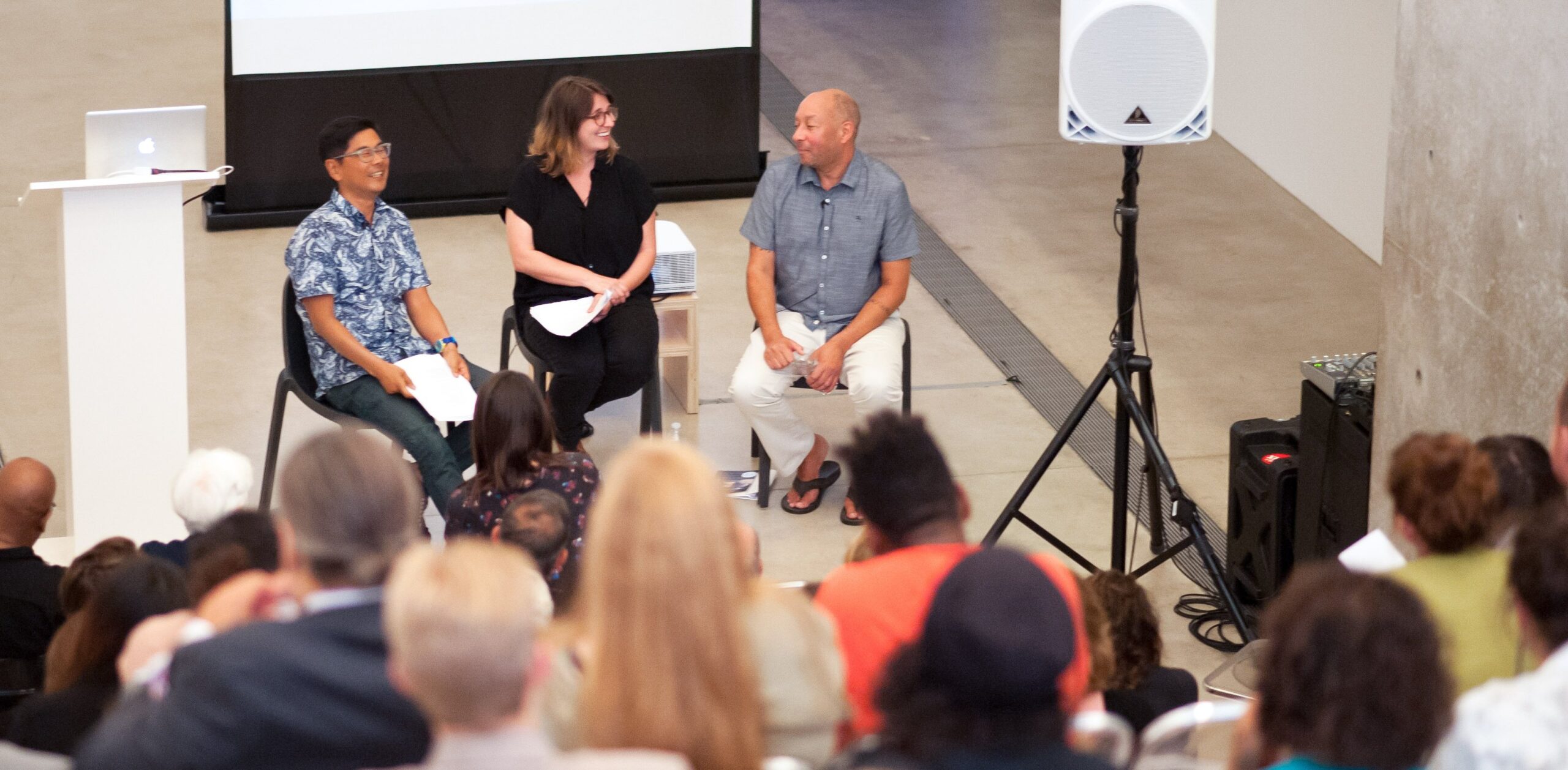 Byron Kim, Jessica Baran, and Carl Phillips sit in the Lower Main Gallery in front of a large audience.