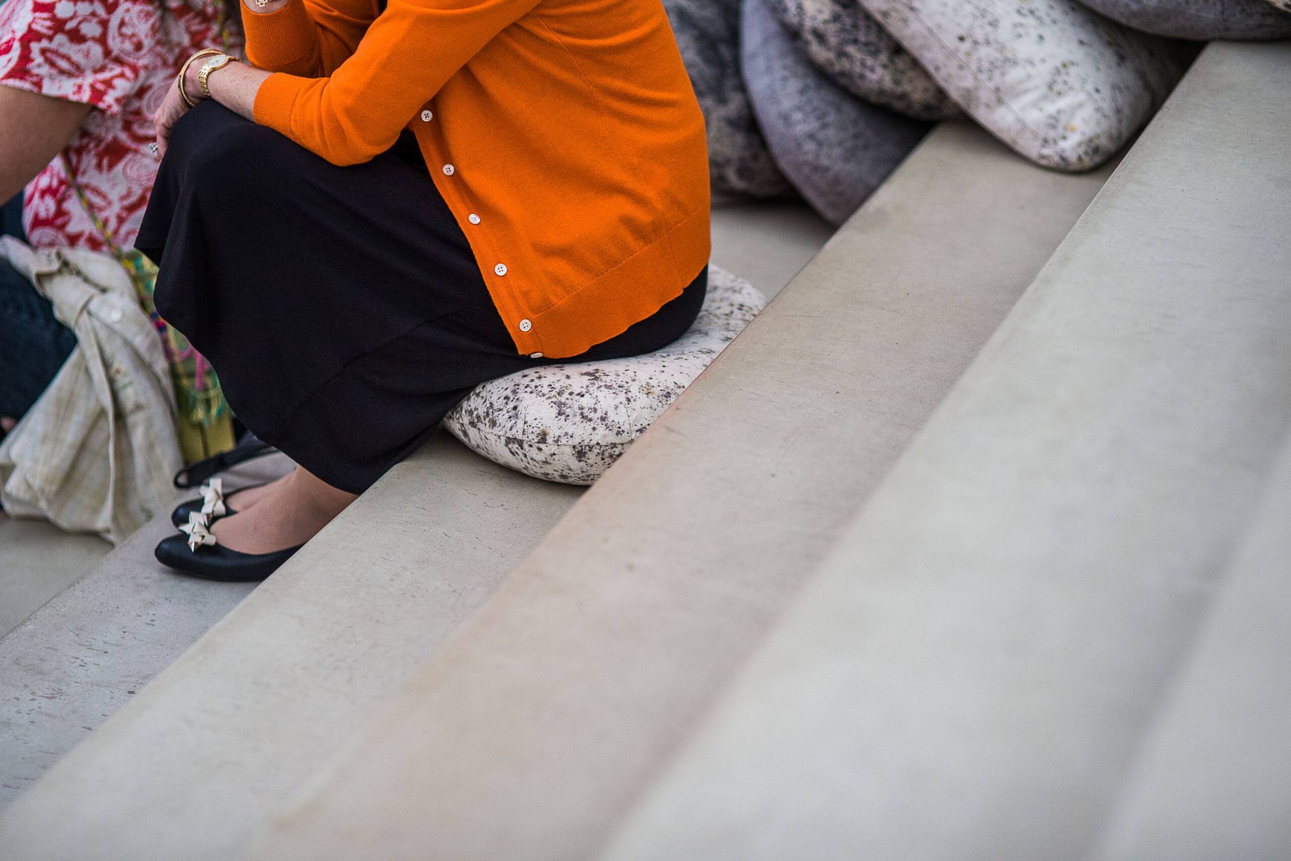 A visitor sits on a small Dosa cushion on the Main Staircase.