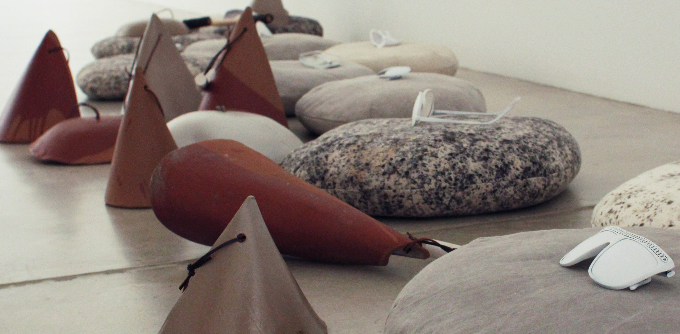 Chris Kallmyer's clay cone bells stand on the floor among meditation pillows holding sensory deprivation glasses.