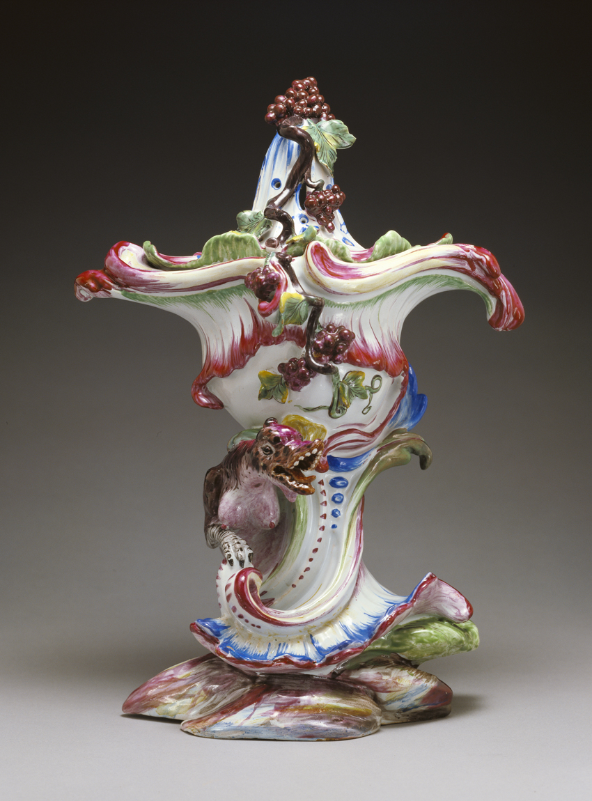 A colorful potpourri vase covered in grape vines and a dragon at the base.