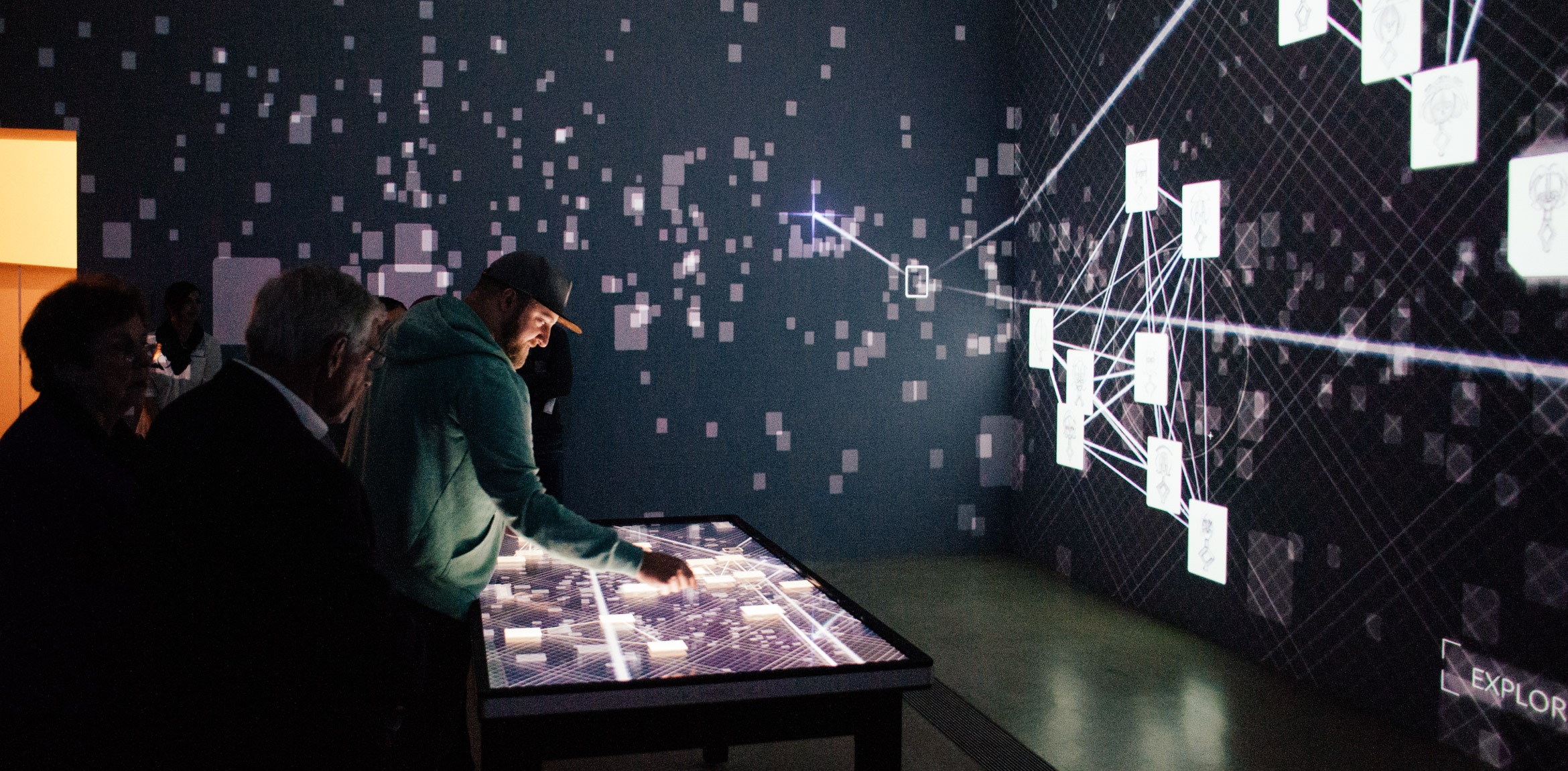 Visitors interact with Rampant Interactive's project, the Kota Data Cloud, a touchscreen table with corresponding projections on the walls of the Cube Gallery.