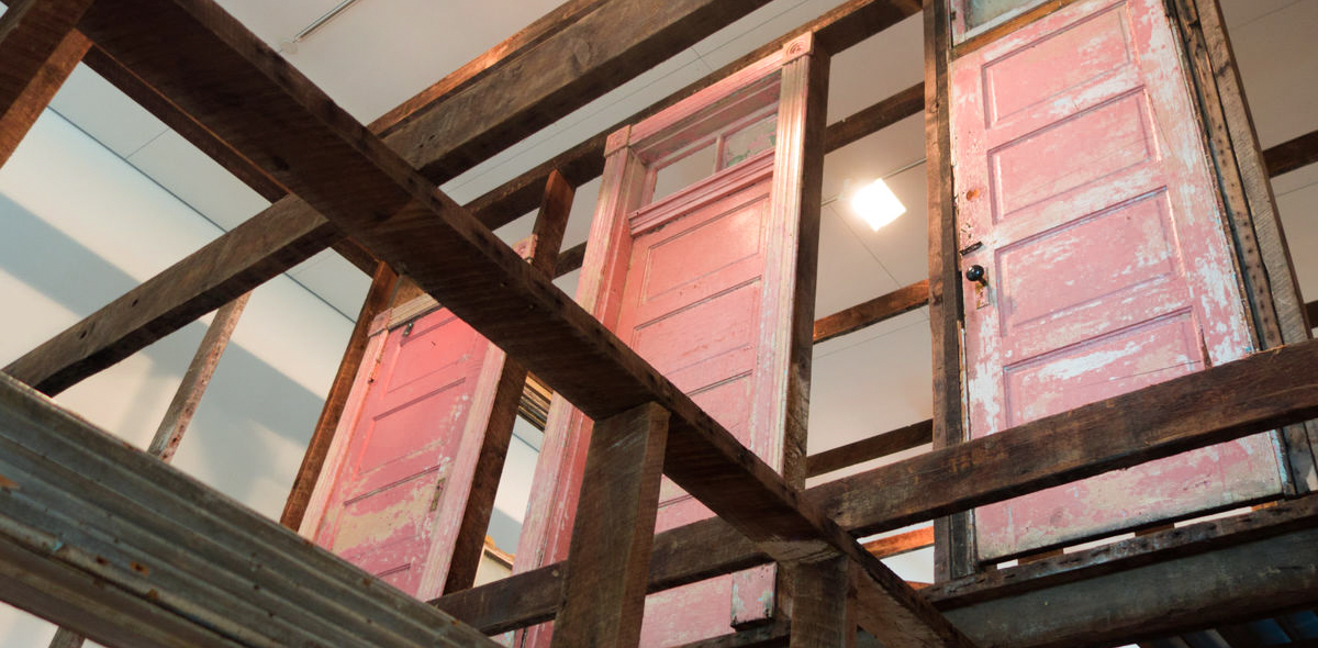 Three red doors viewed up underneath on the first floor of raumlaborberlin's installation 