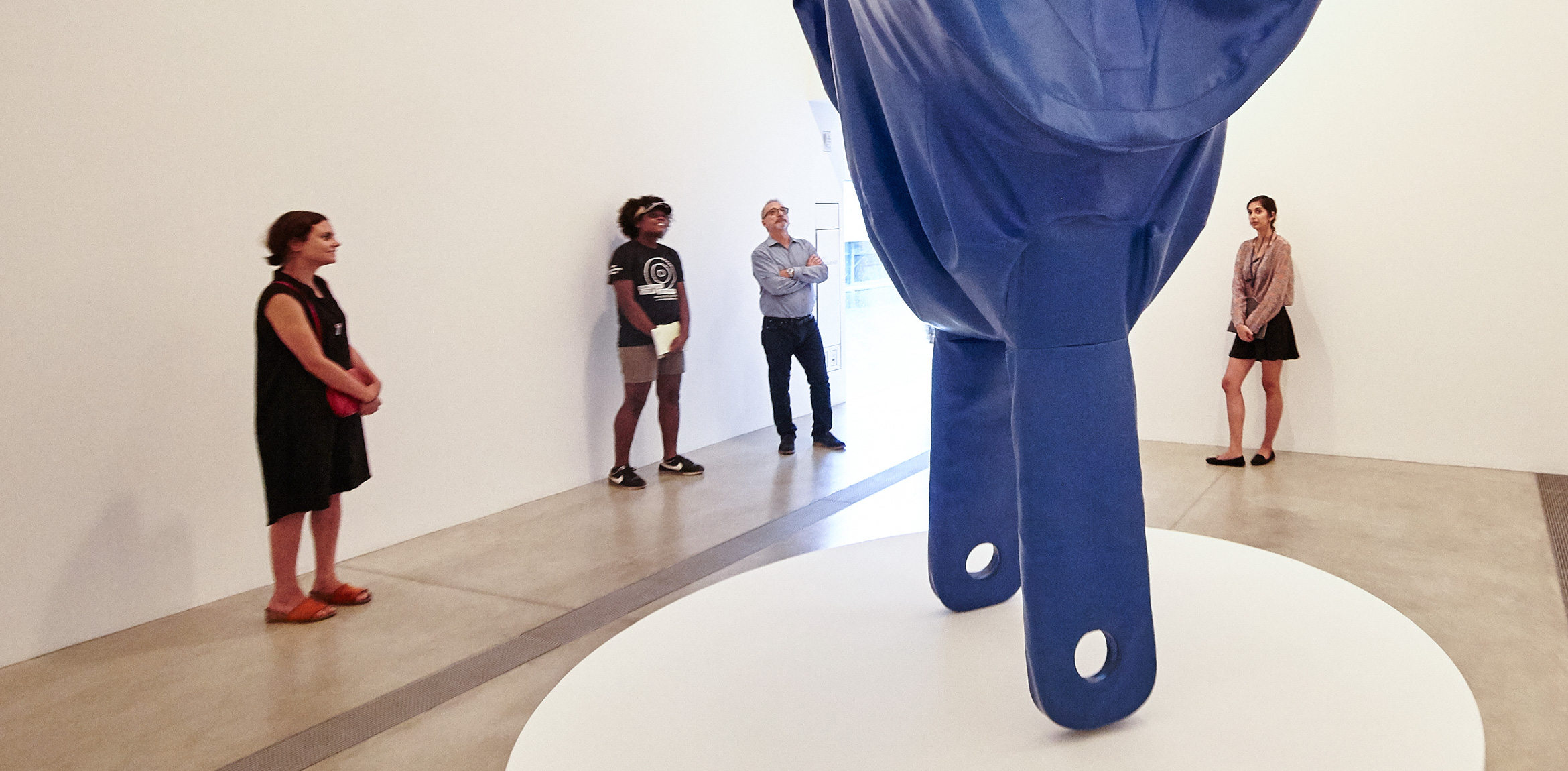 Visitors gather around Claes Oldenburg's sculpture 