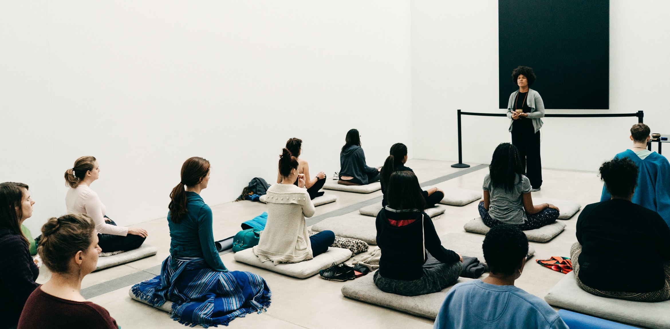 Simiya Sudduth leads a group in meditation in the Lower Main Gallery.
