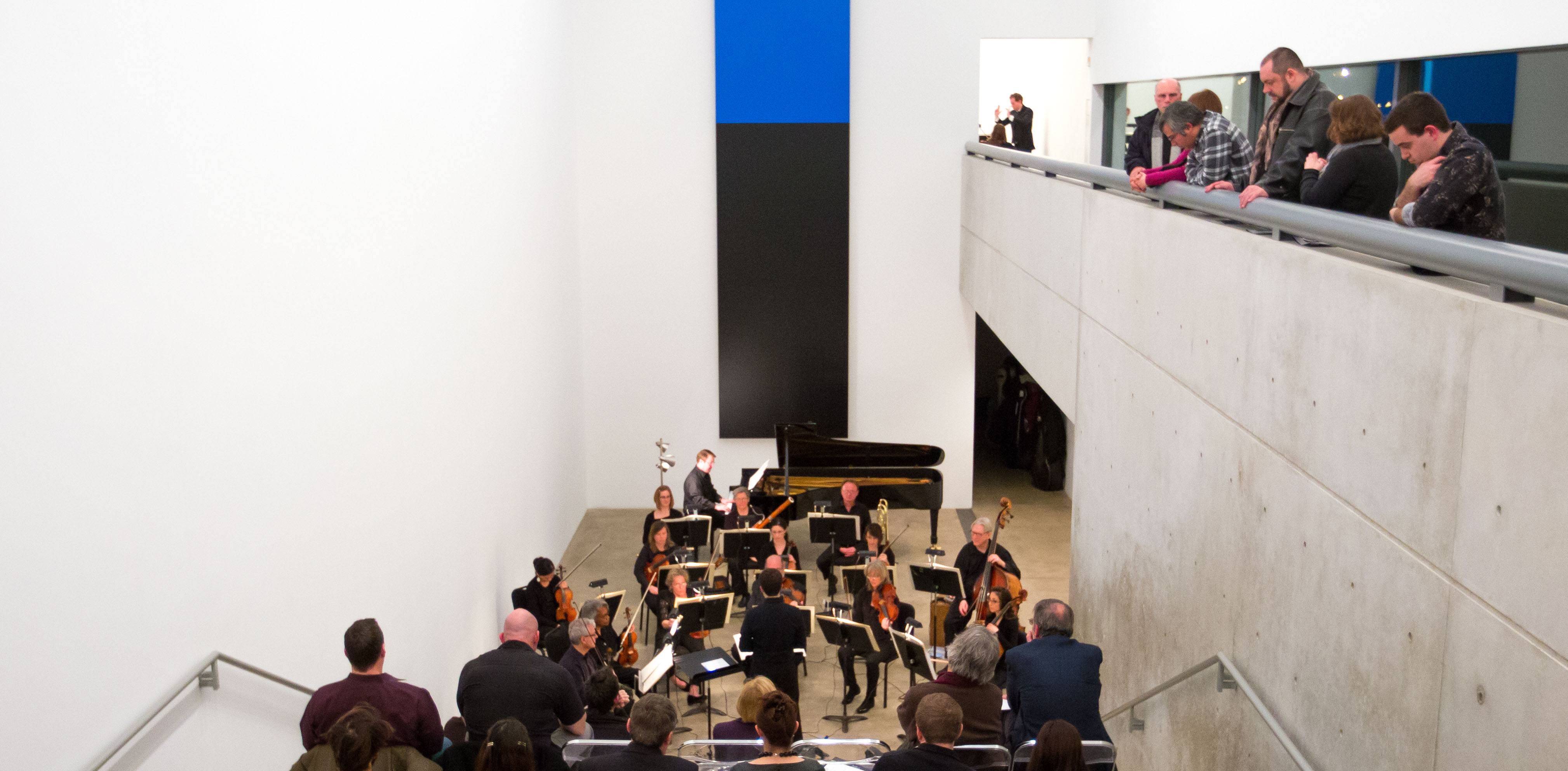 Members of the symphony perform in the Lower Main Gallery and the Cube Gallery for audience members.