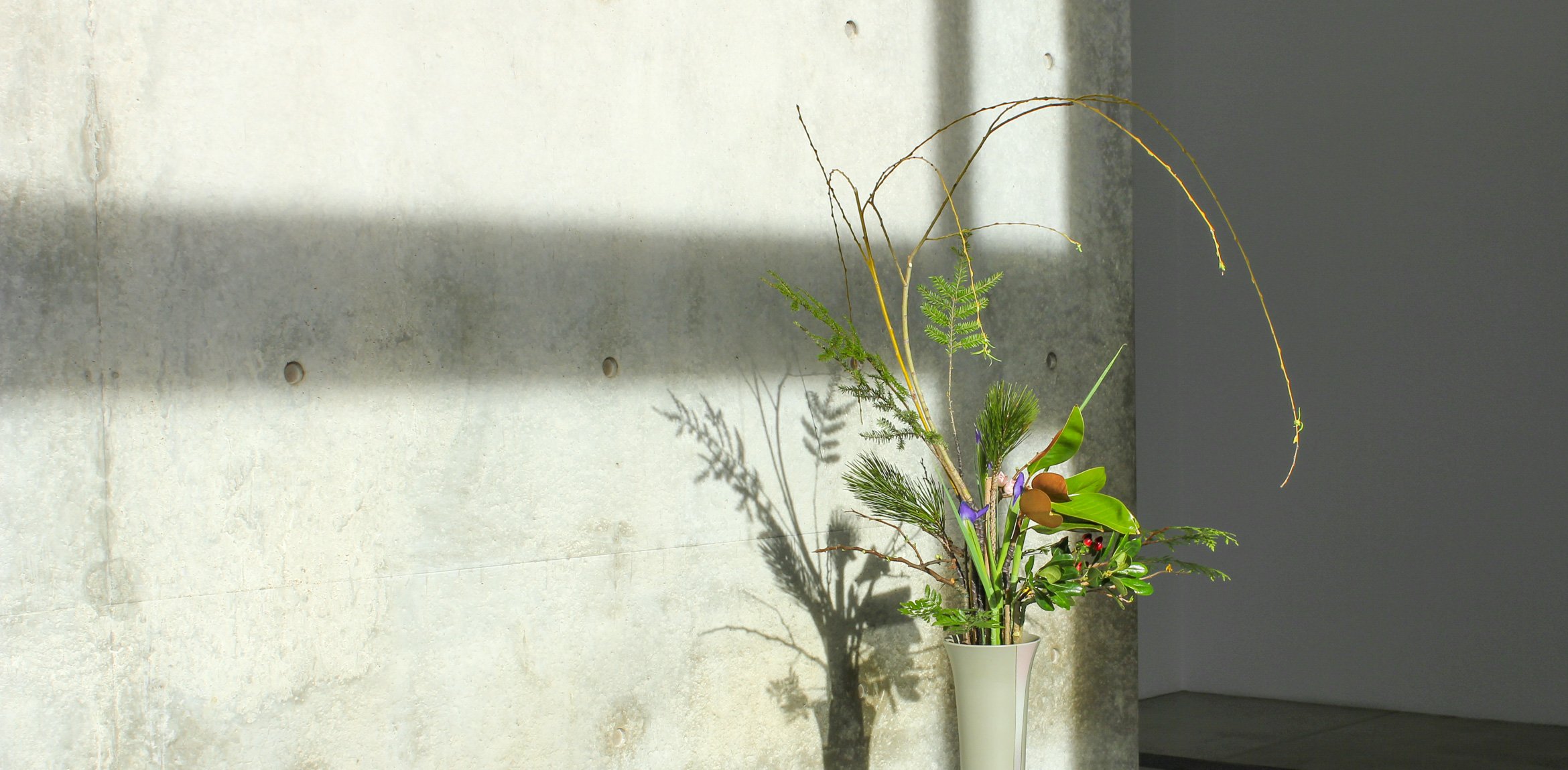 A floral arrangement against a Tadao Ando concrete wall.