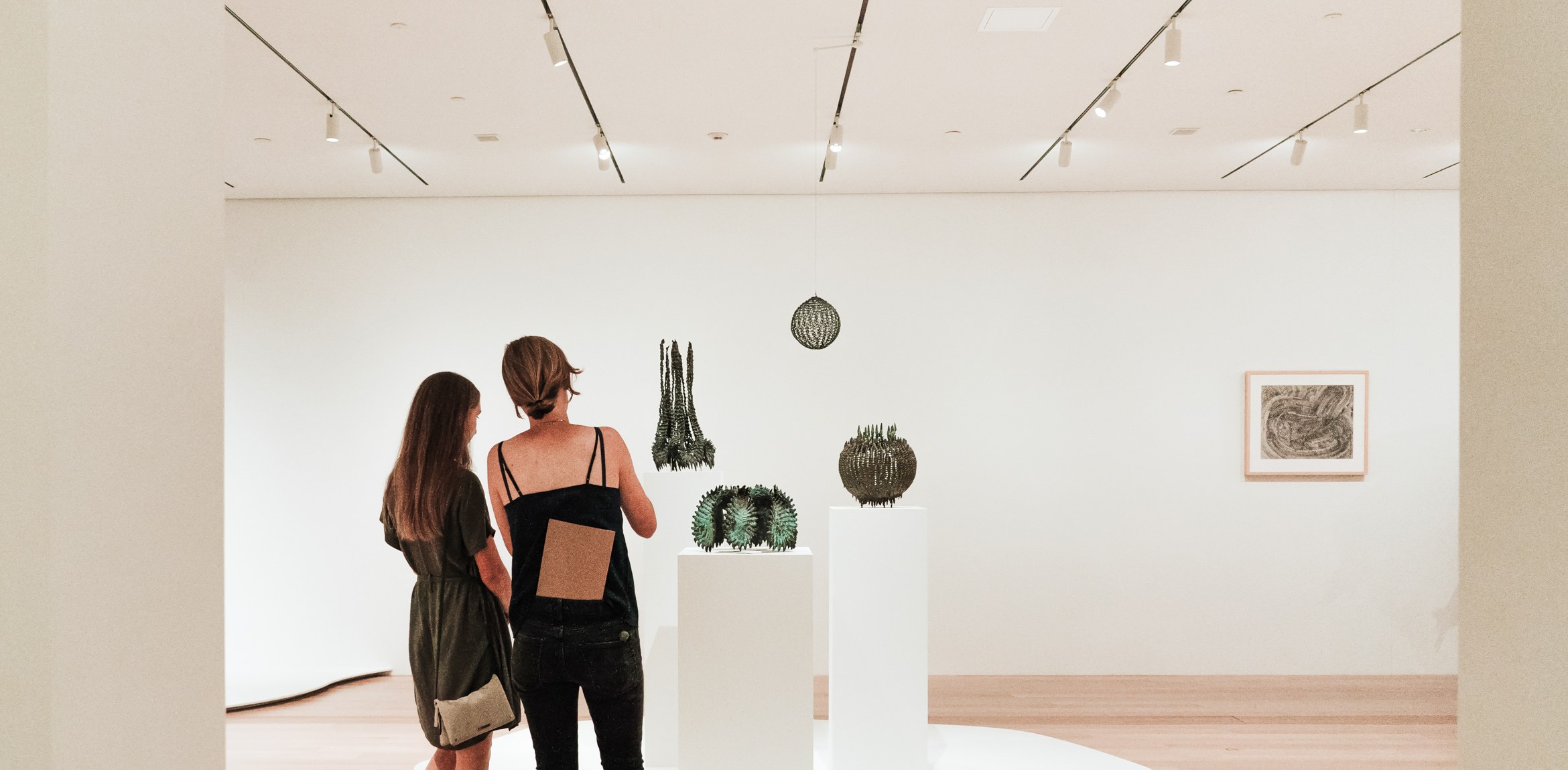 Two visitors view works by Ruth Asawa in the Lower East Gallery.