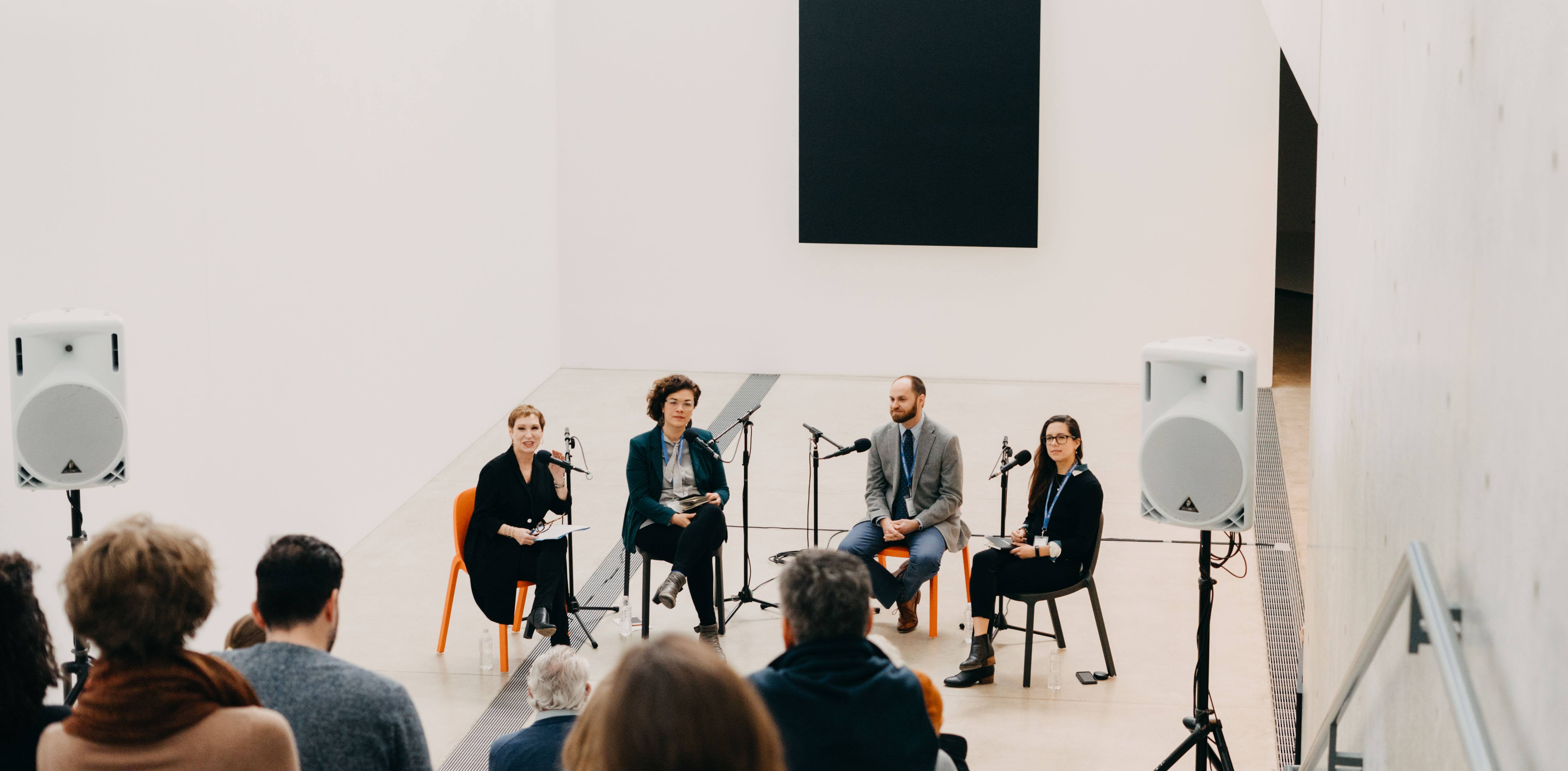 Colby Heckendorn, Miriam Ruiz, Sue Bell Yank, and moderator Roseann Weiss sit in the Lower Main Gallery and speak to the audience on the Main Staircase.