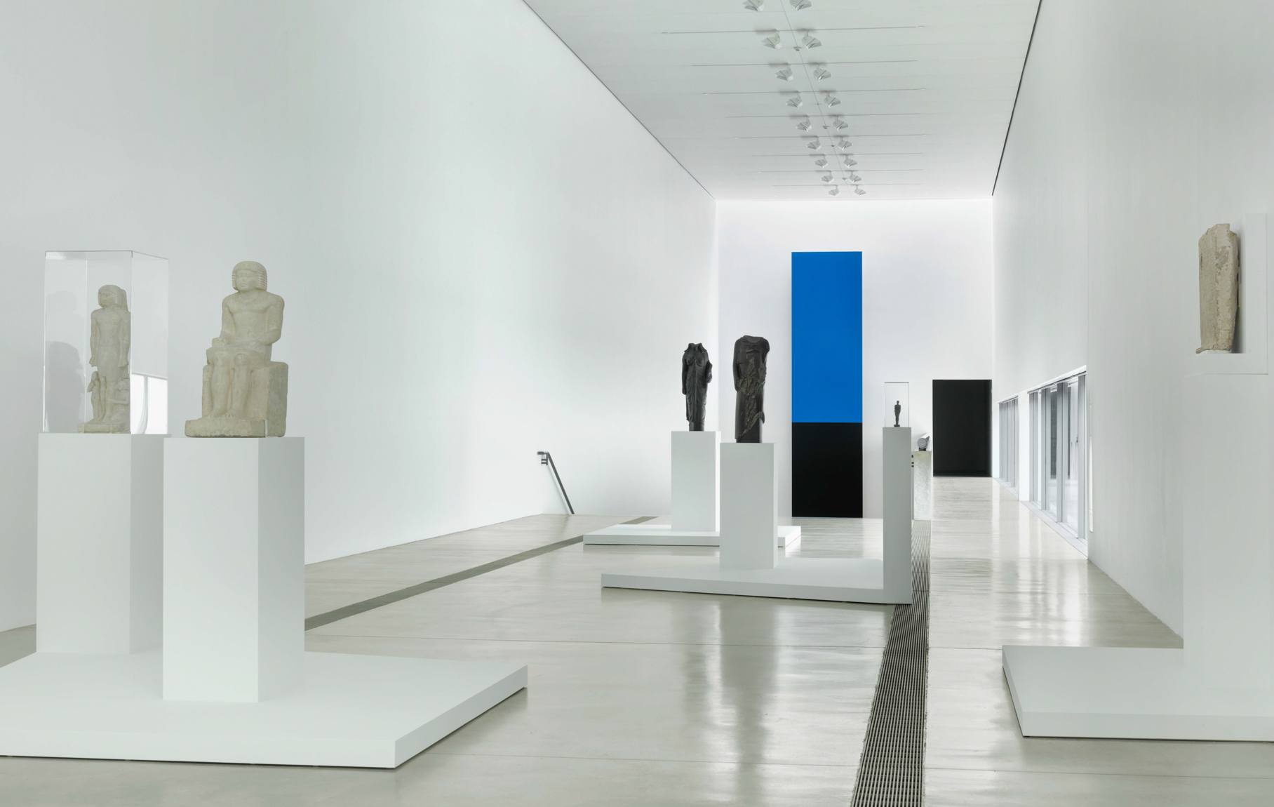 A view of Egyptian sculptures on podiums and vitrines in the Main Gallery.